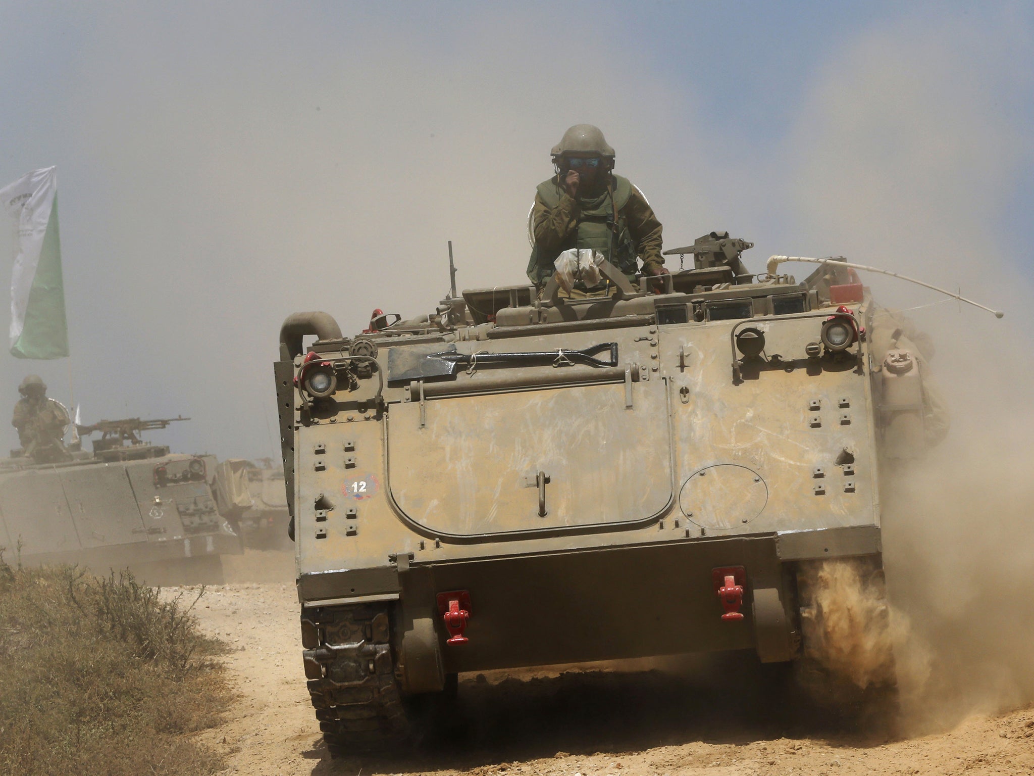 Israeli soldiers on armored personnel carriers move to a new position on the Israel-Gaza Border