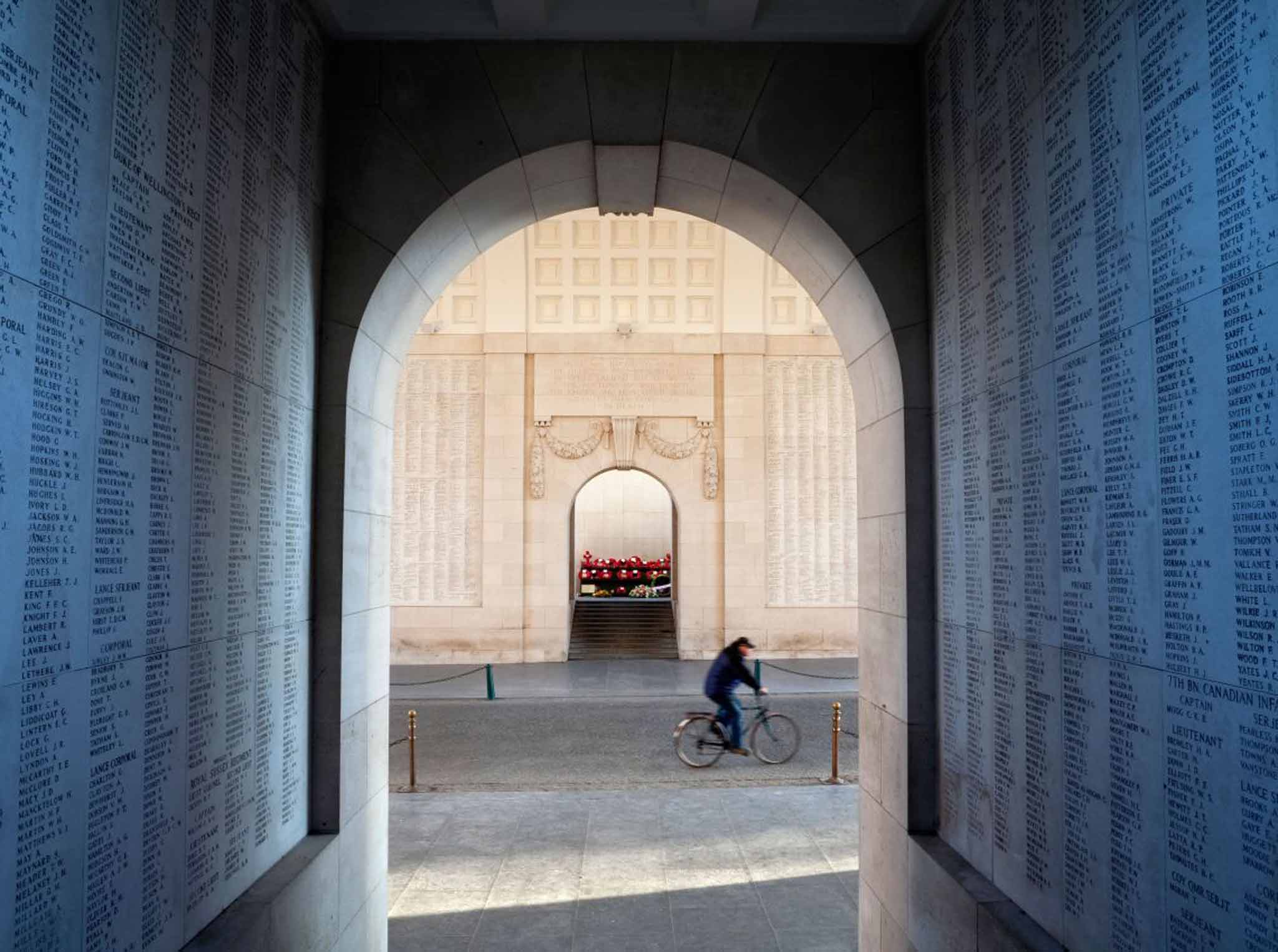 Roll call: a cyclist passes Menin Gate