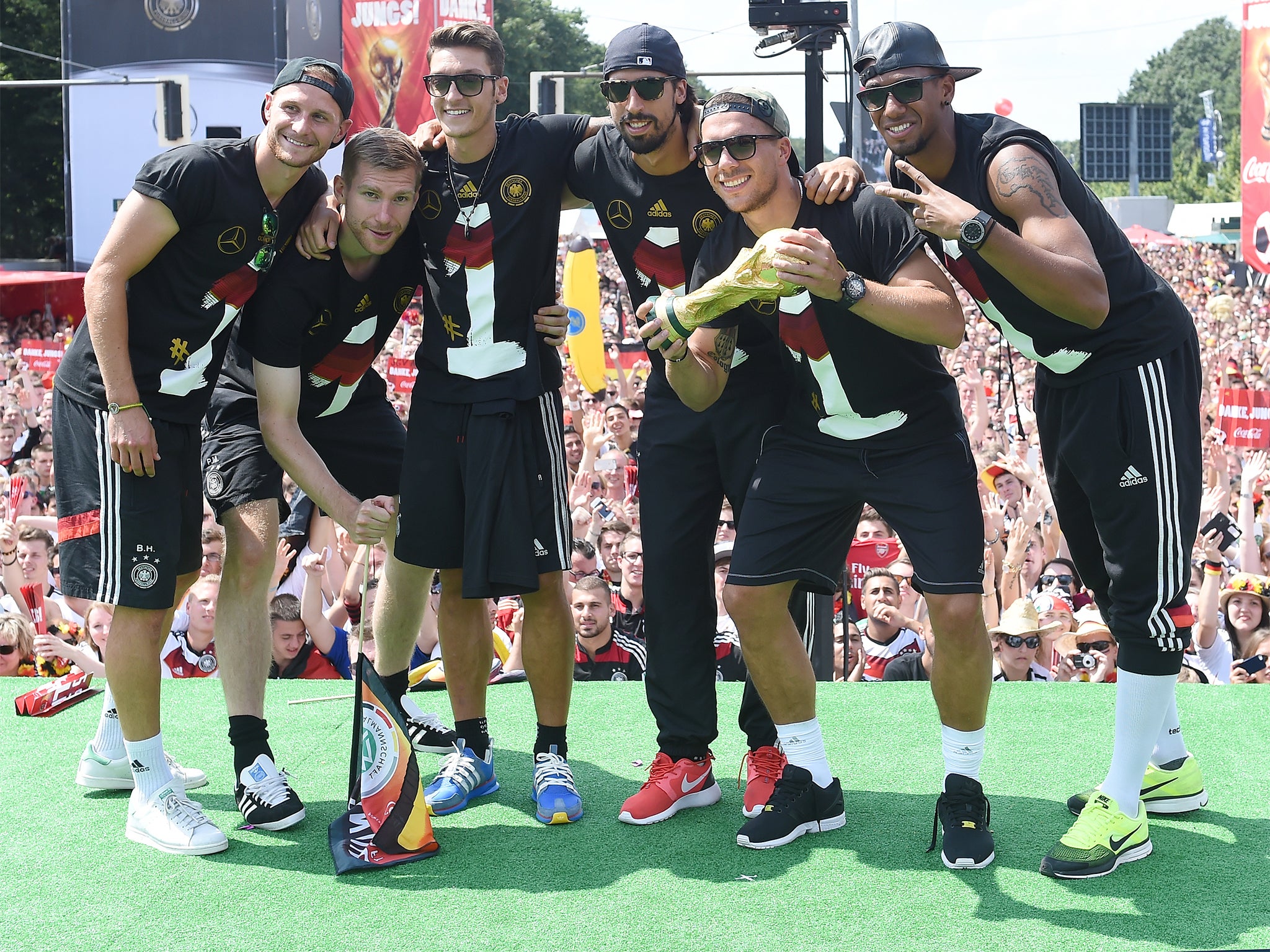 Benedikt Hoewedes, Per Mertesacker, Mesut Oezil, Sami Khedira, Lukas Podolski and Jerome Boateng pose with the World Cup trophy during the celebrations in Berlin