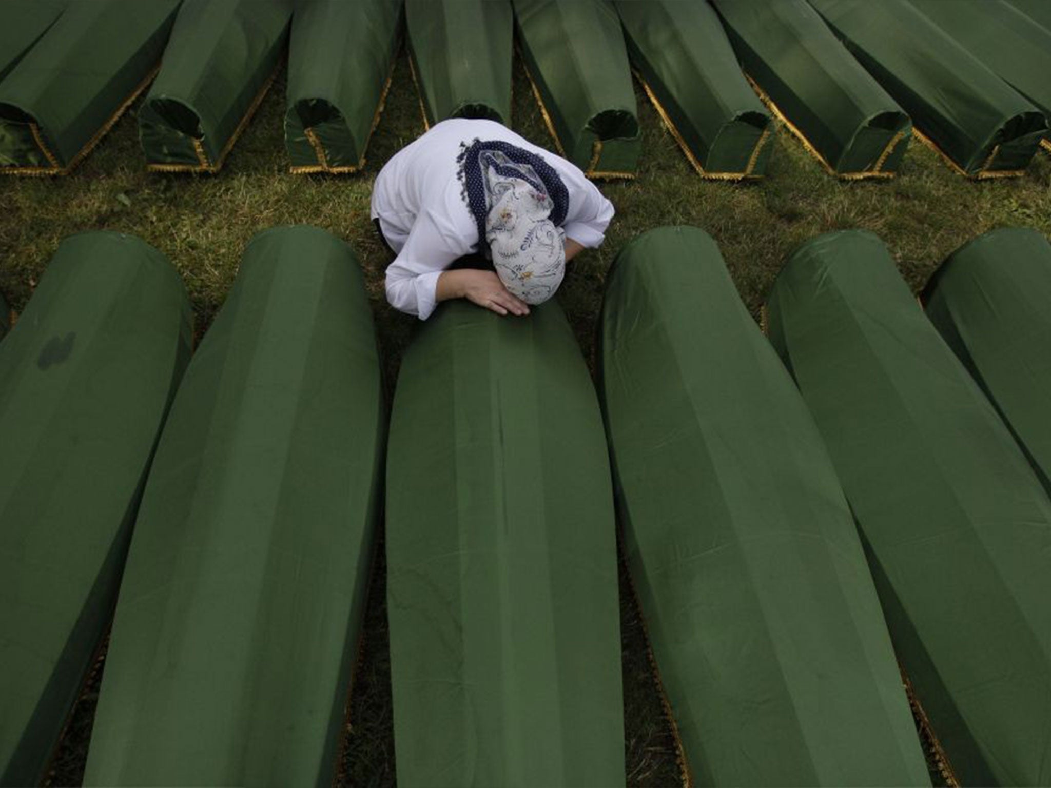 A Bosnian woman as she cries near the coffin of her relative during a funeral ceremony at the memorial center in Potocari, near Srebrenica, in 2013