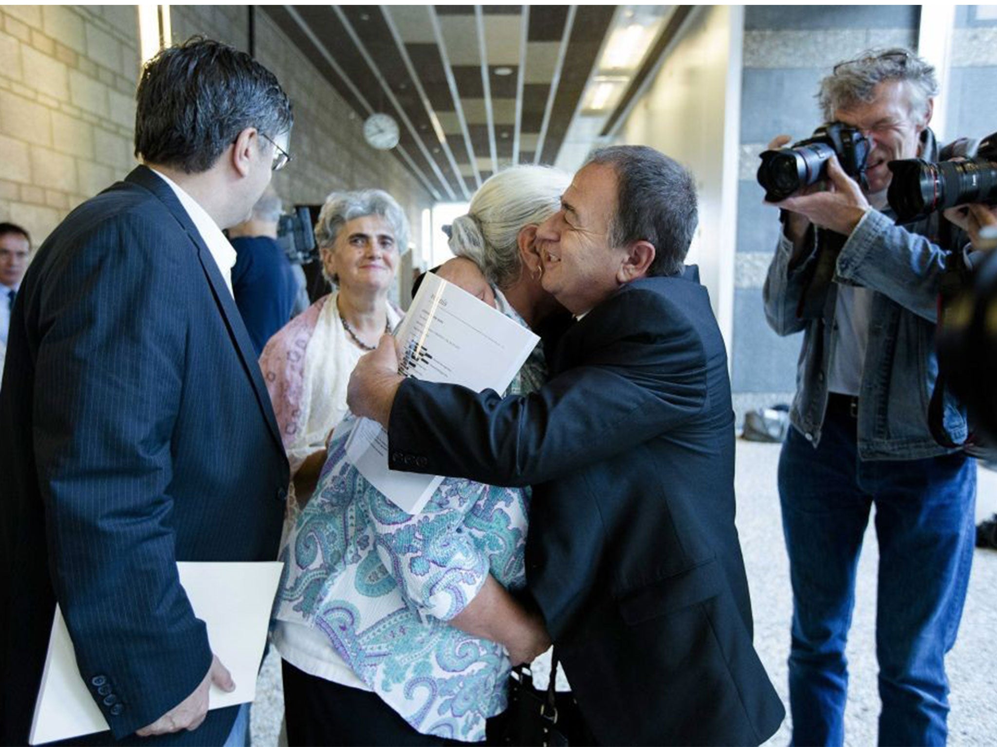 Bosnian woman of the 'Srebrenica Mothers Association' is hugged by a relative after the announcement of the verdict (EPA)