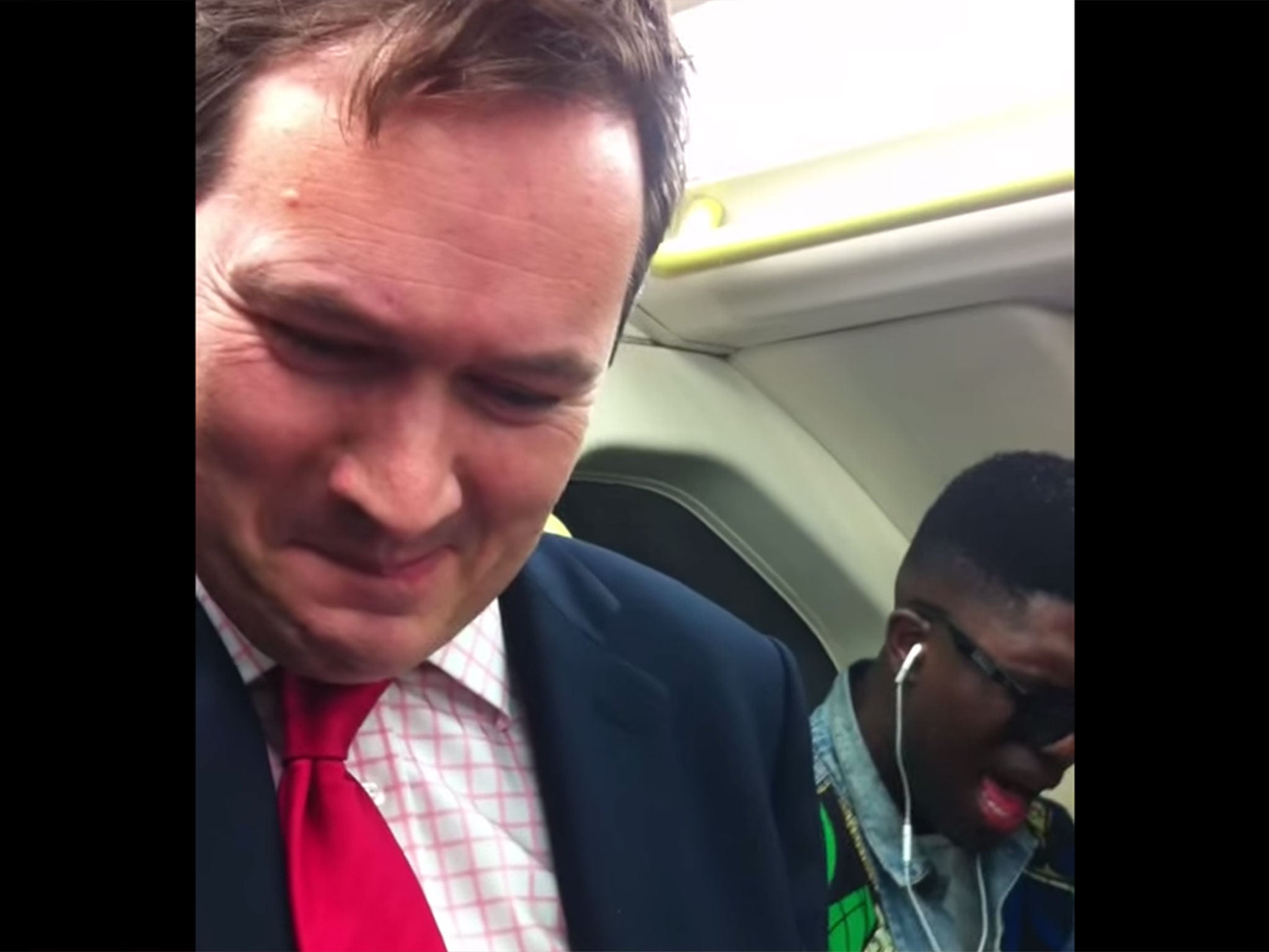 A commuter attempting to laugh as a fellow passenger