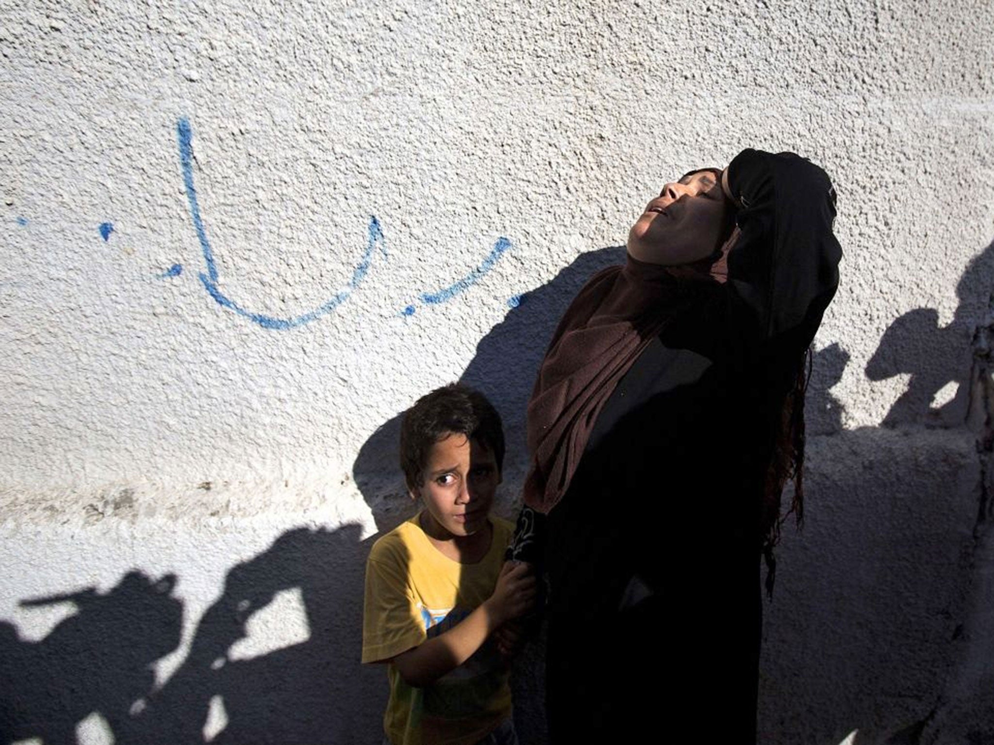 A relative of four boys killed in an airstrike grieves during their funeral in Gaza City (AFP)