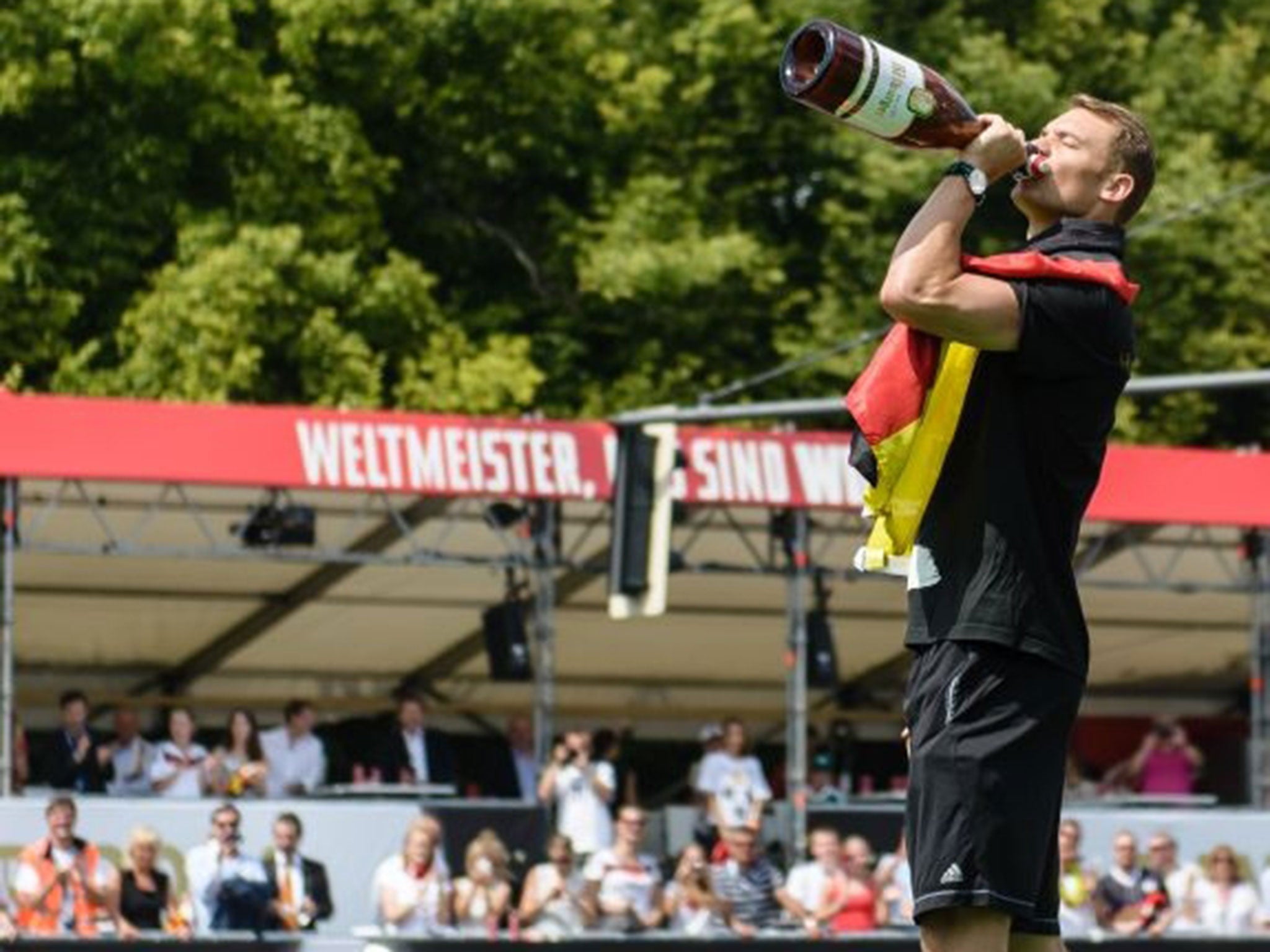 A German fan wears the national colors as he watches, with a beer in his hand, the FIFA World Cup 2014 final football match Germany vs Argentina played in Brazil during an outdoor viewing at the Olympic stadium in Munich, southern Germany on July 13, 2014