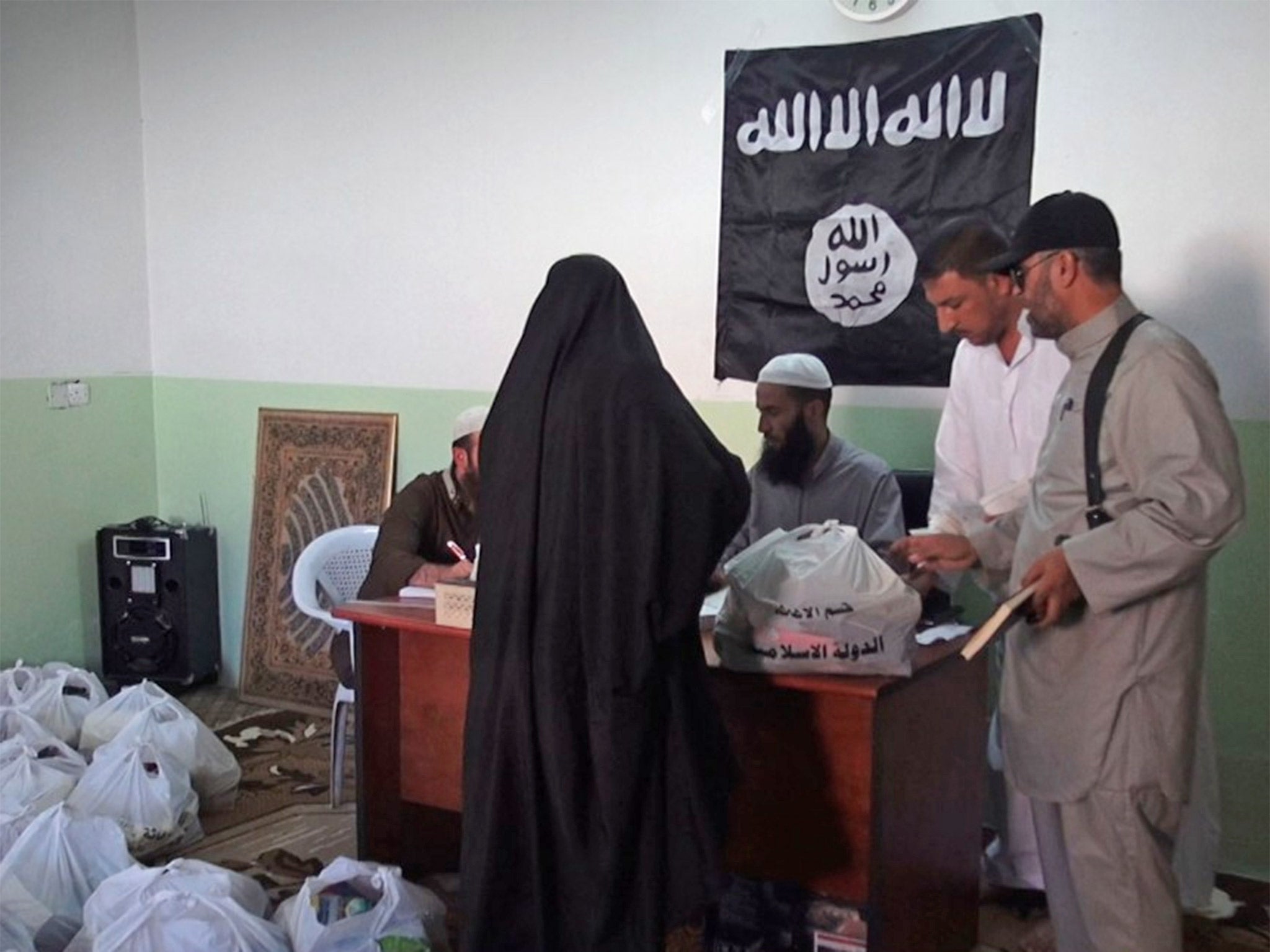 A woman collecting aid administered by Isis in Syria