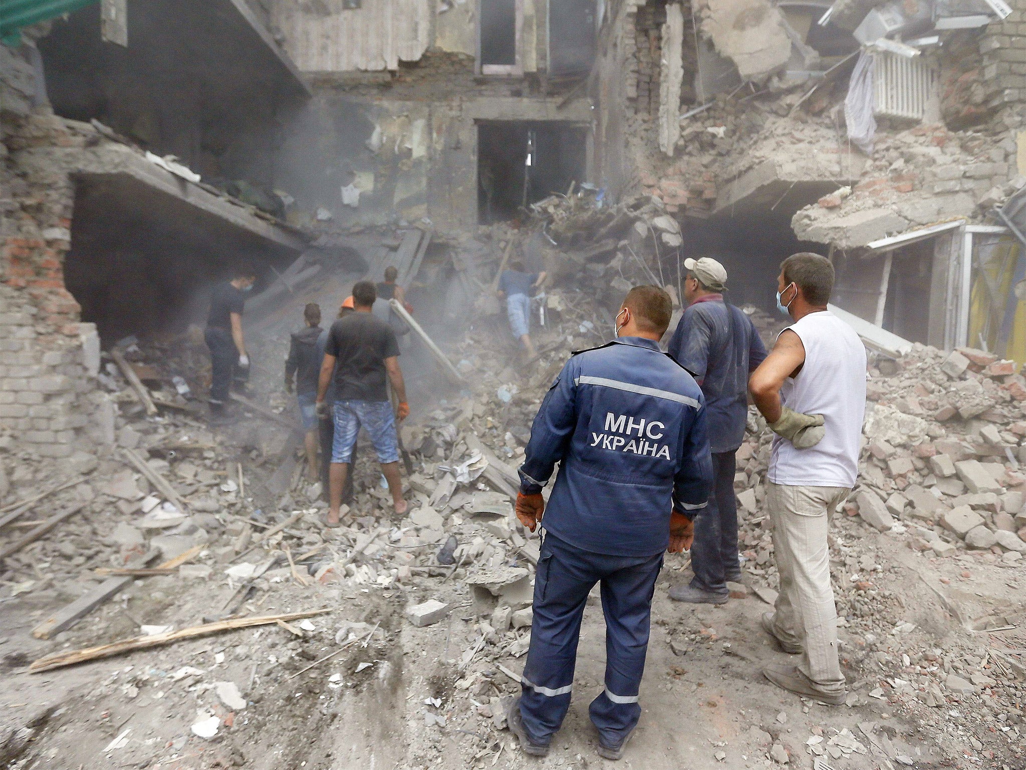 Rescue workers and local residents remove debris of an apartment building hit by missile during an air strike in the eastern Ukrainian town of Snizhne, 100 km east of Donetsk (Getty)