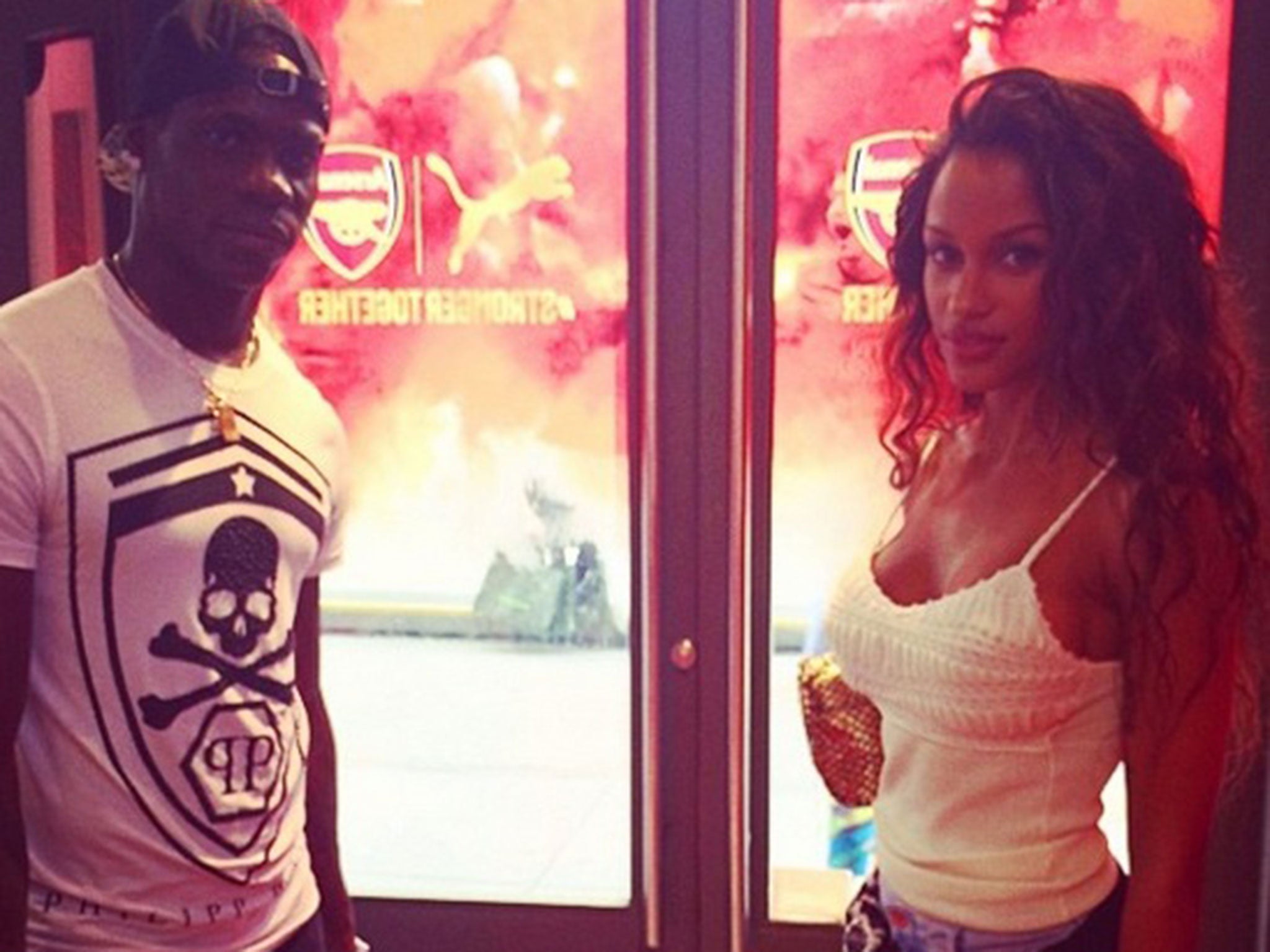 Mario Balotelli and Fanny Neguesha pose with Arsenal badges