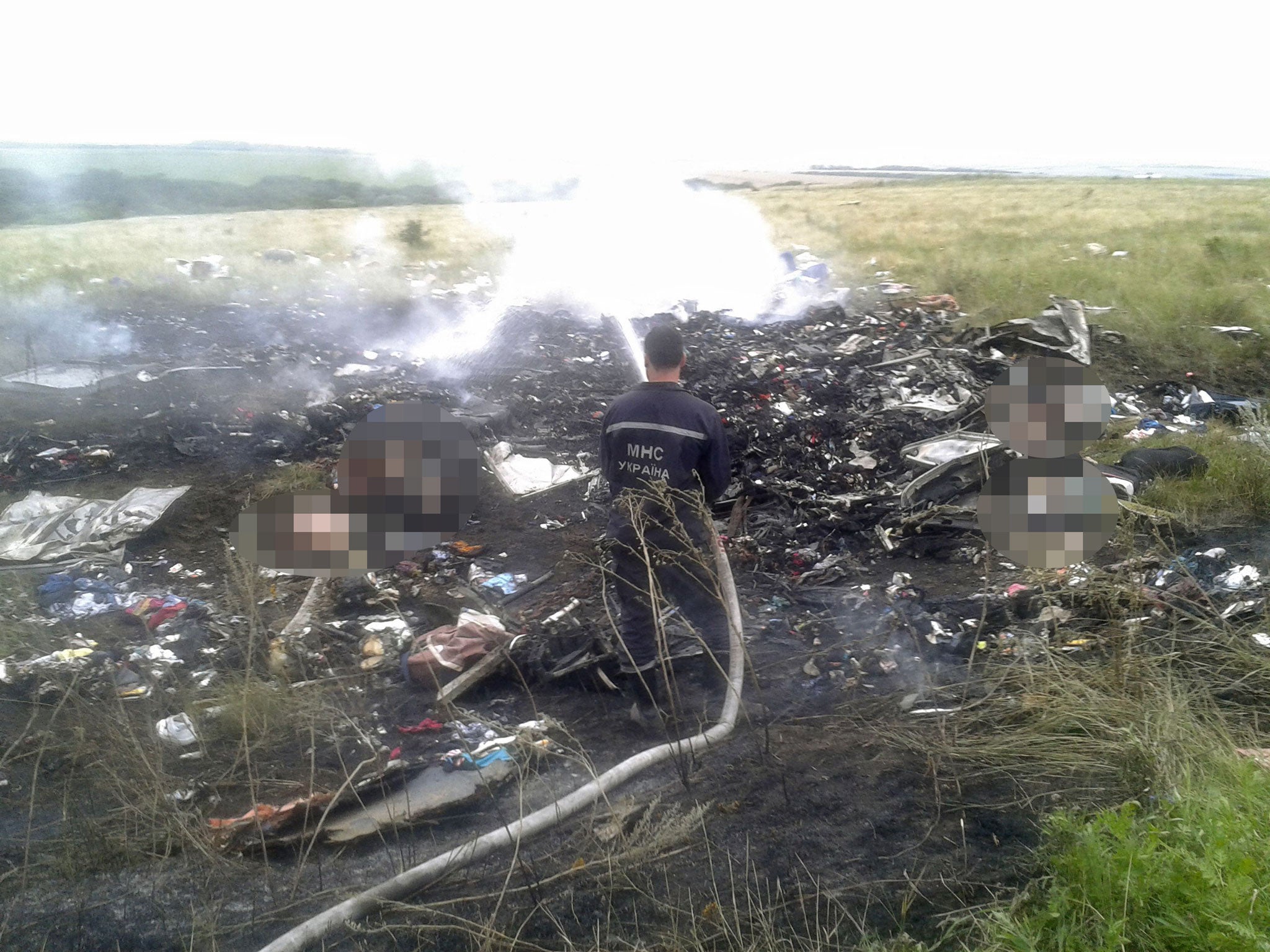A man works at putting out a fire at the site of the plane crash
