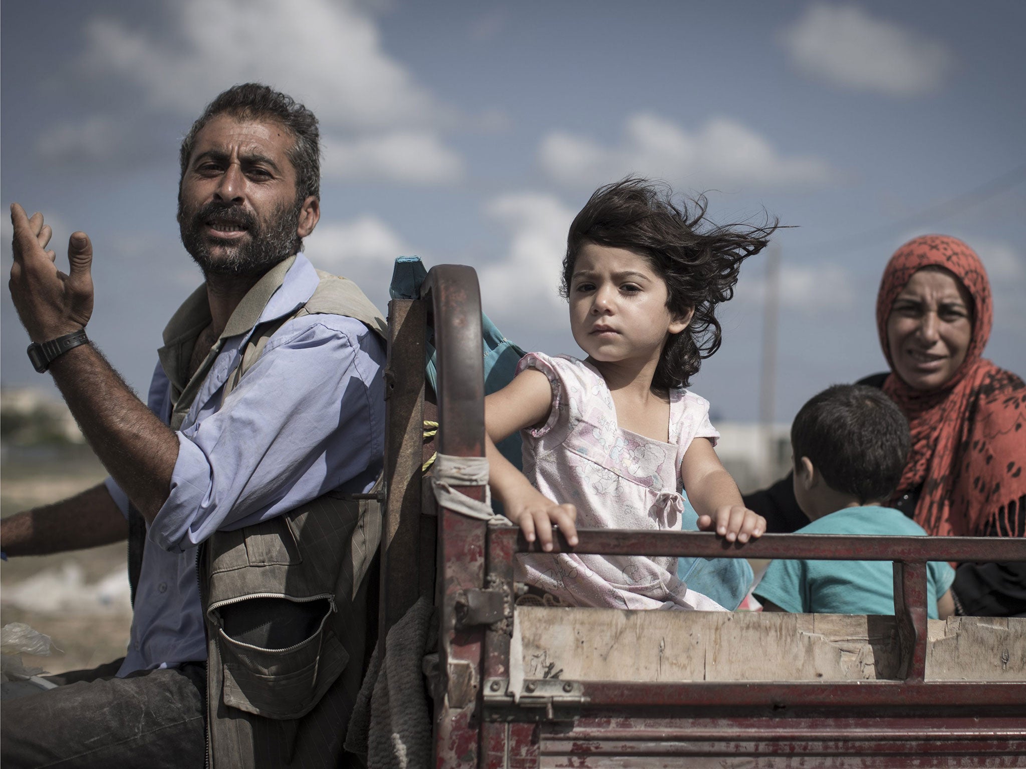 A Palestinian family who fled their home as Israeli troops began their ground invasion of Gaza travel to the shelter of a UN school in Khan Younis yesterday