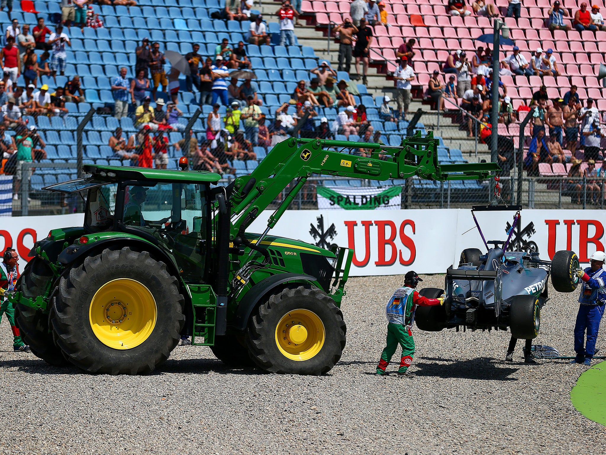 Lewis Hamilton's Mercedes is dragged out of the barrier at the Sachs hairpin