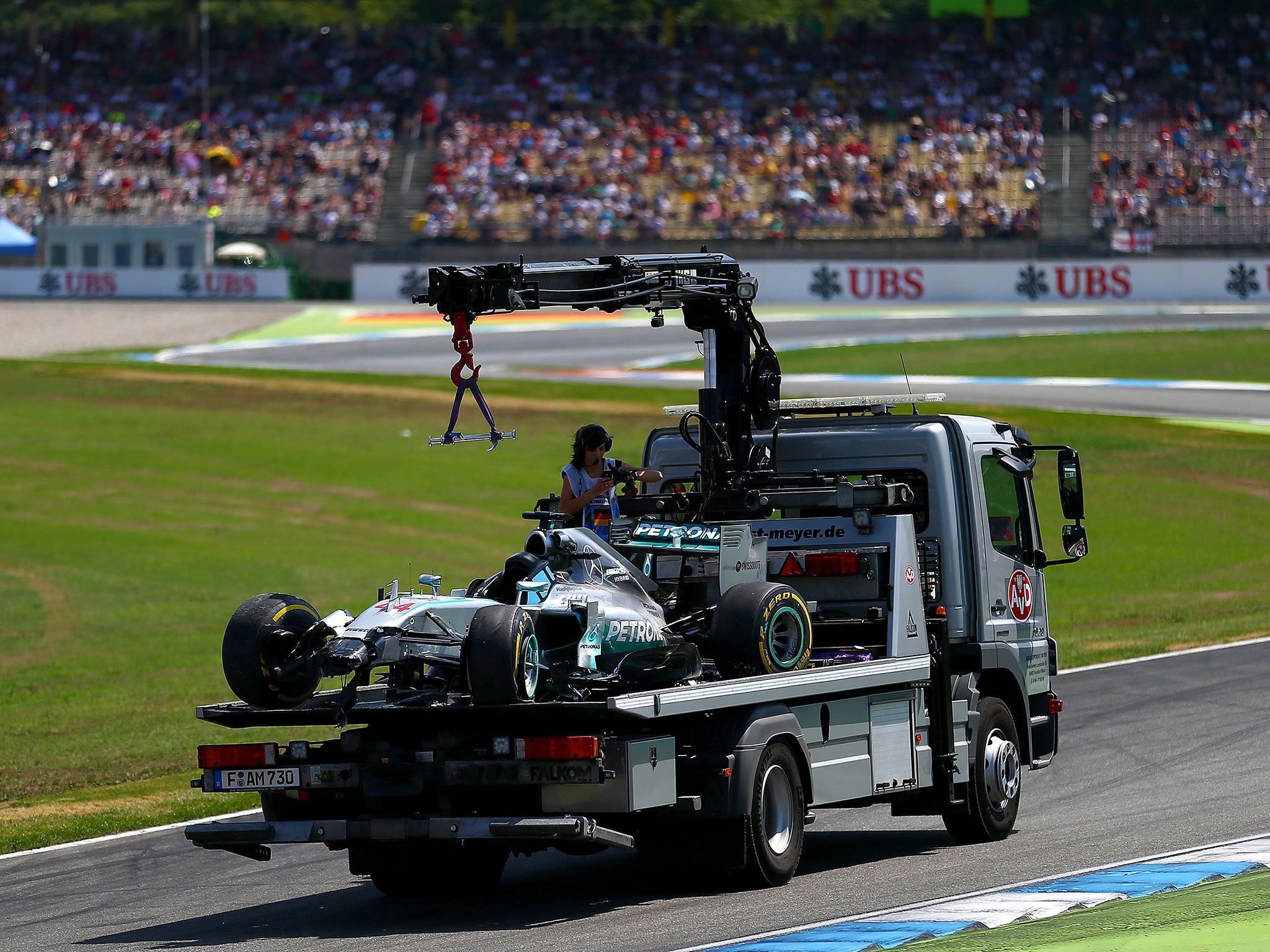 Lewis Hamilton's Mercedes is taken away on the back of a lorry after crashing out of Q1