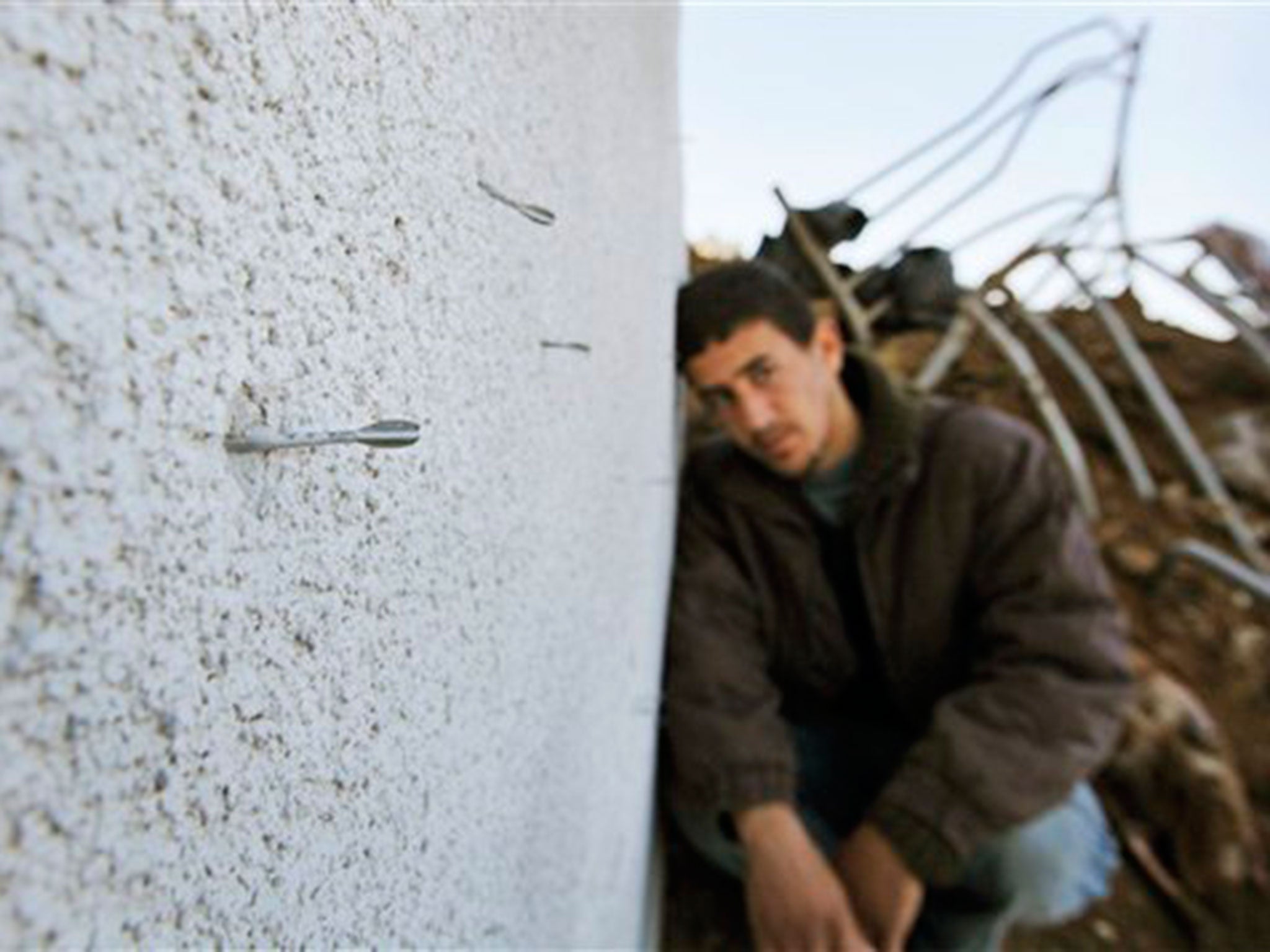 File: A Palestinian looks on as a small pointed metal dart known as a flechette, usually spread over a wide area in large numbers from a shell, is seen sticking out of the wall of a destroyed house in Mughraka, Gaza, on 21 January, 2009 (AP)