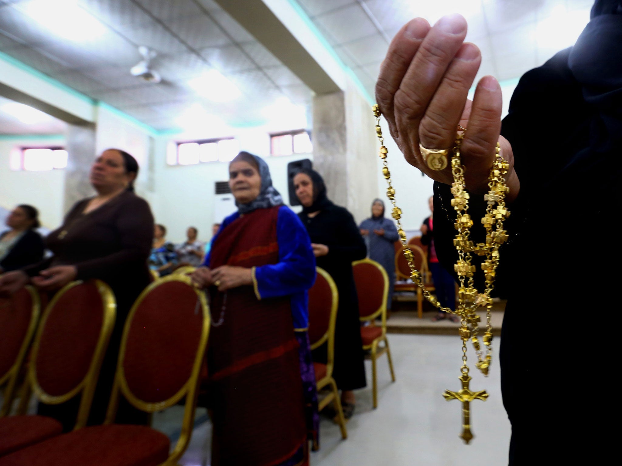 Displaced Christians who fled the violence in Mosul pray at Mar Aframa church in Qaraqoush on the outskirts of the city. Many have been stripped of their possessions