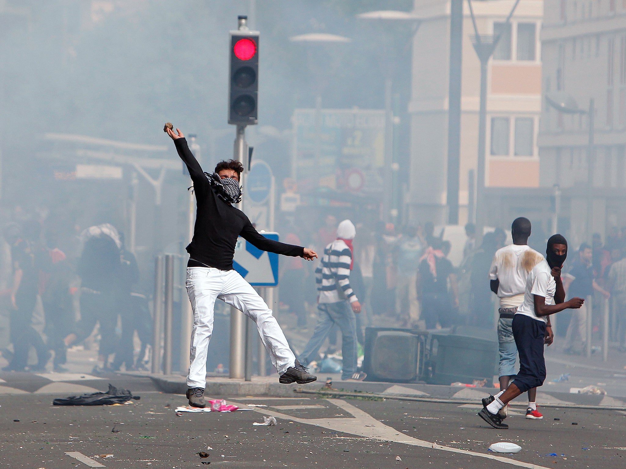 A rioter throws a stone towards riot police following a pro-Palestinians demonstration, in Sarcelles, north of Paris