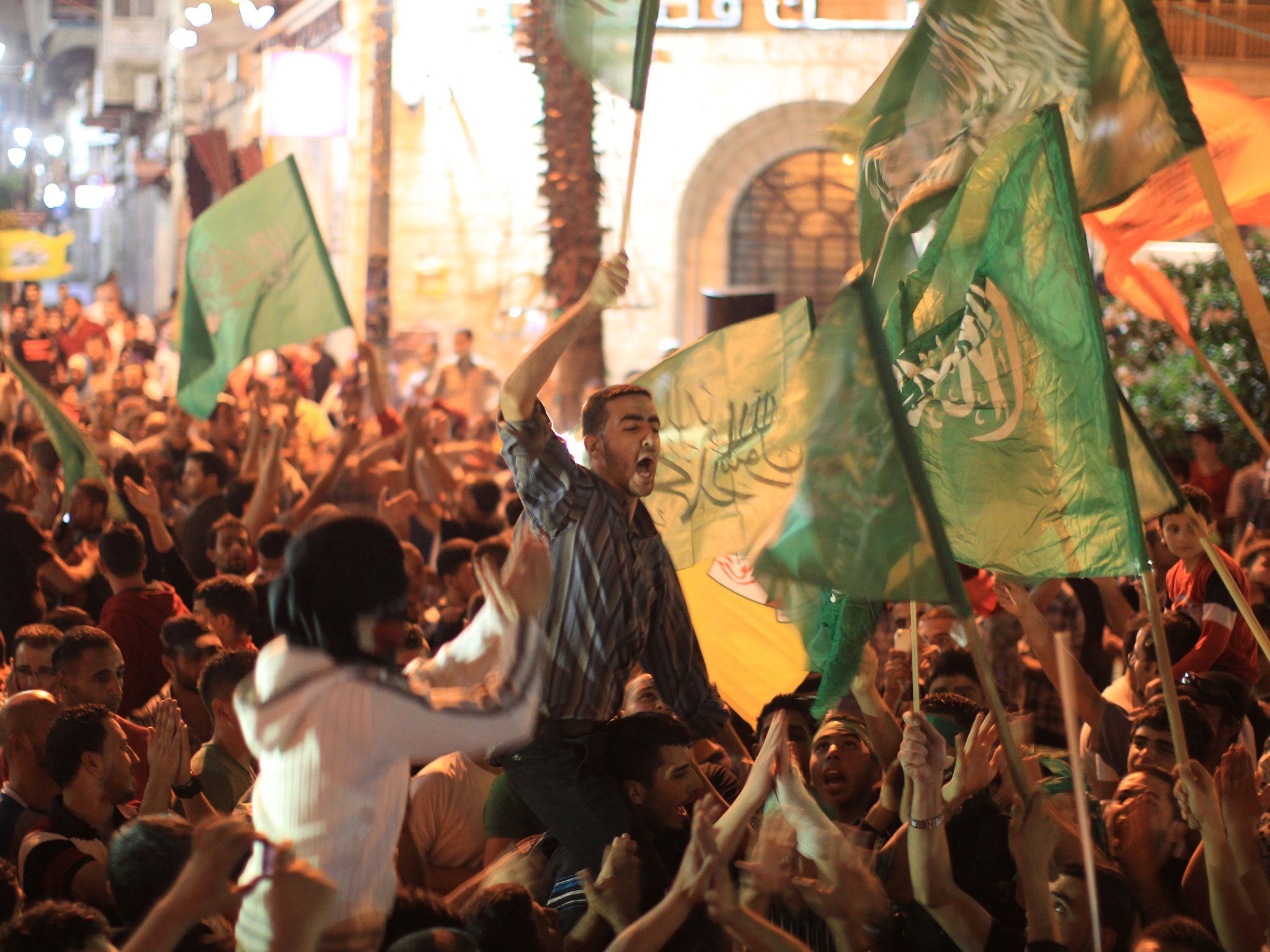 Palestinians celebrate in the West Bank city of Ramallah, late July 21, 2014, after Hamas' armed wing, the Ezzedine al-Qassam Brigades, said it had captured an Israeli soldier