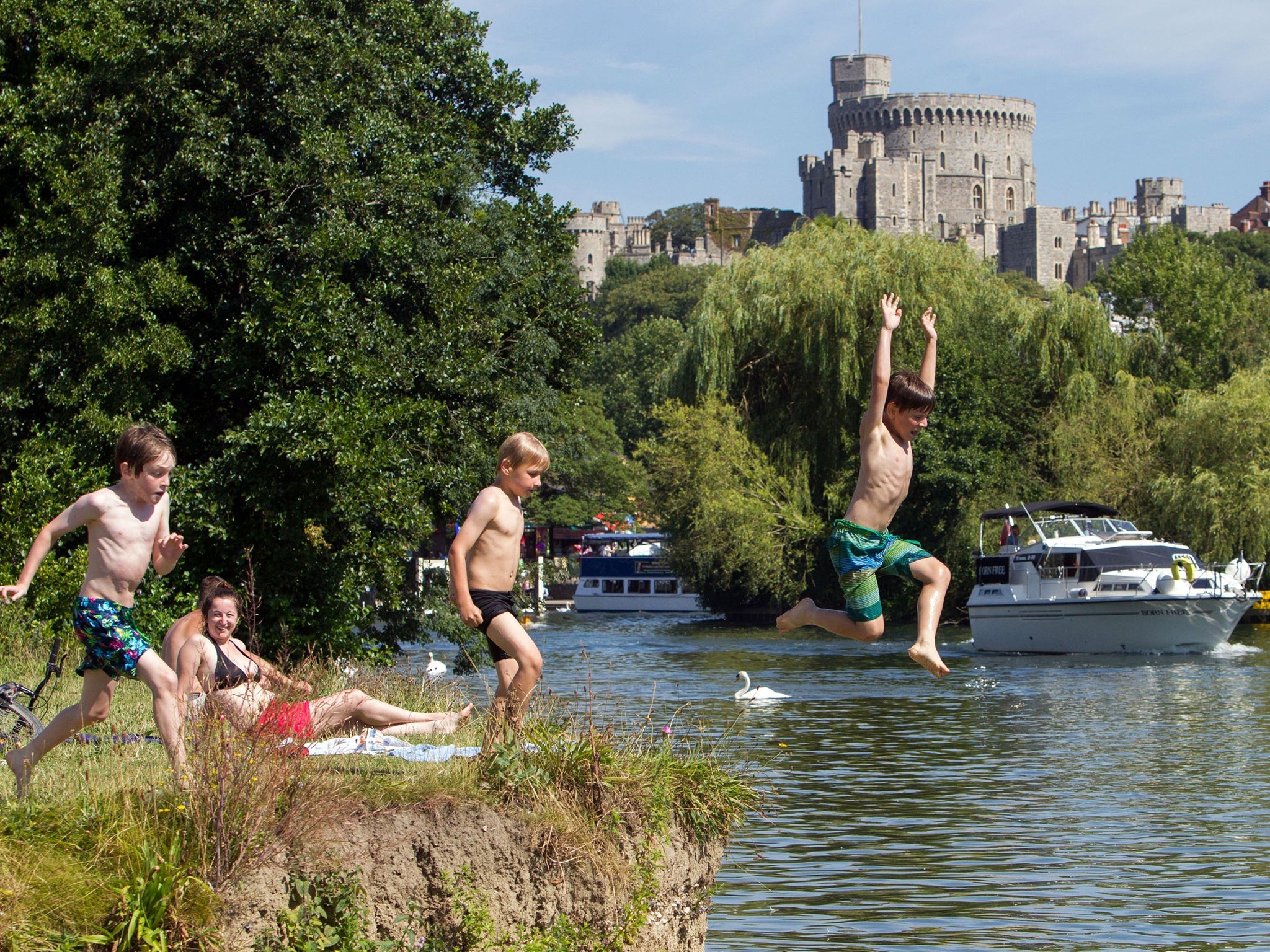 Elliott Duko (R) with Charles Keen (L) and Harry O'Shaughnesy (C) cool off by jumping into river Thames in Windsor