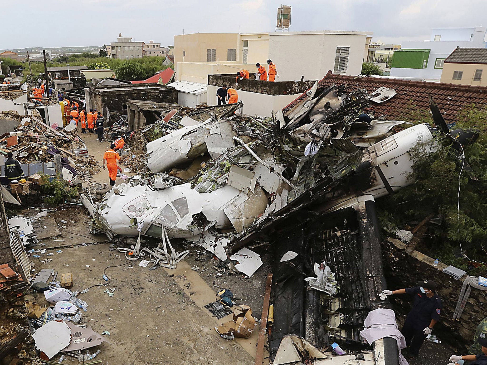 Rescue personnel survey the wreckage of a TransAsia Airways turboprop plane that crashed, on Taiwan's offshore island Penghu