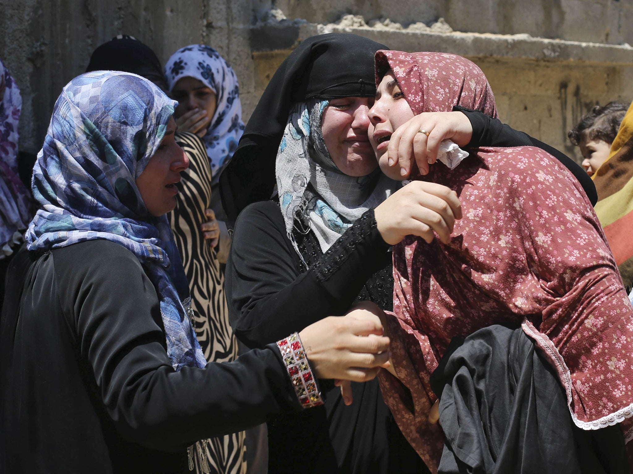 Palestinian relatives of Tawfiq al -Aga, who medics said was killed in Israeli shelling, mourn during his funeral in Khan Younis in the southern Gaza Strip