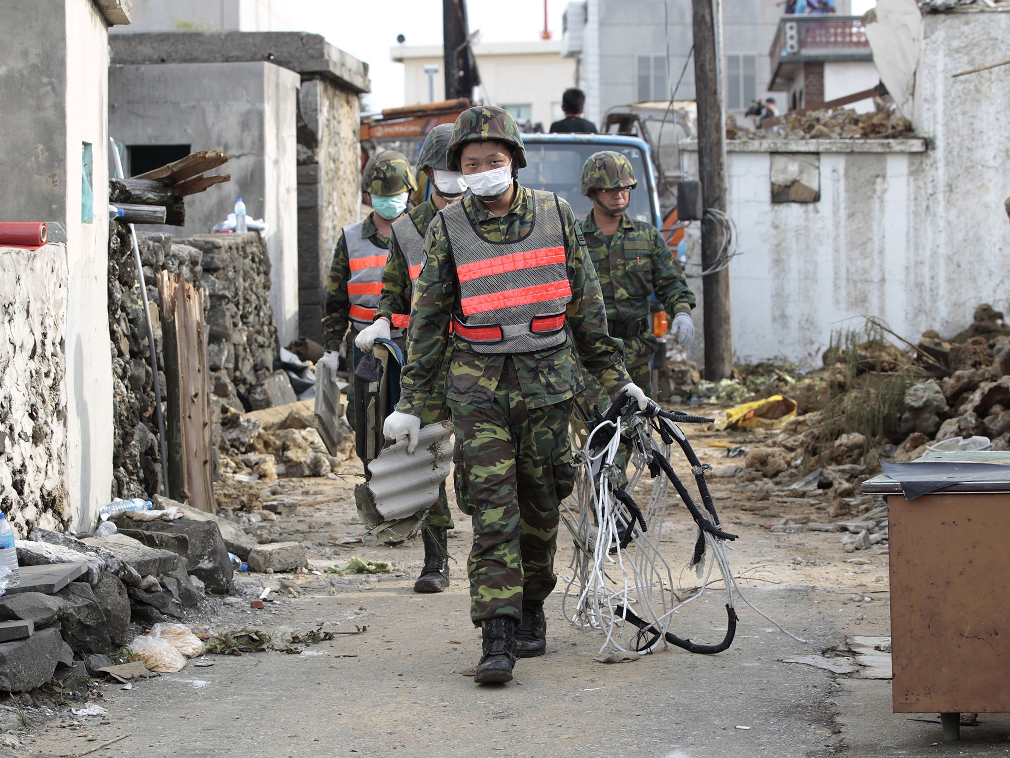 Soldiers remove debris from the scene of crashed TransAsia Airways Flight GE222 on the outlying island of Penghu