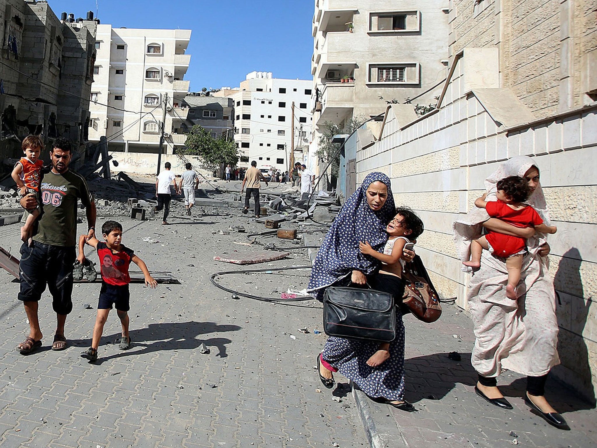 Palestinians flee from Israeli air strikes in Gaza City last year