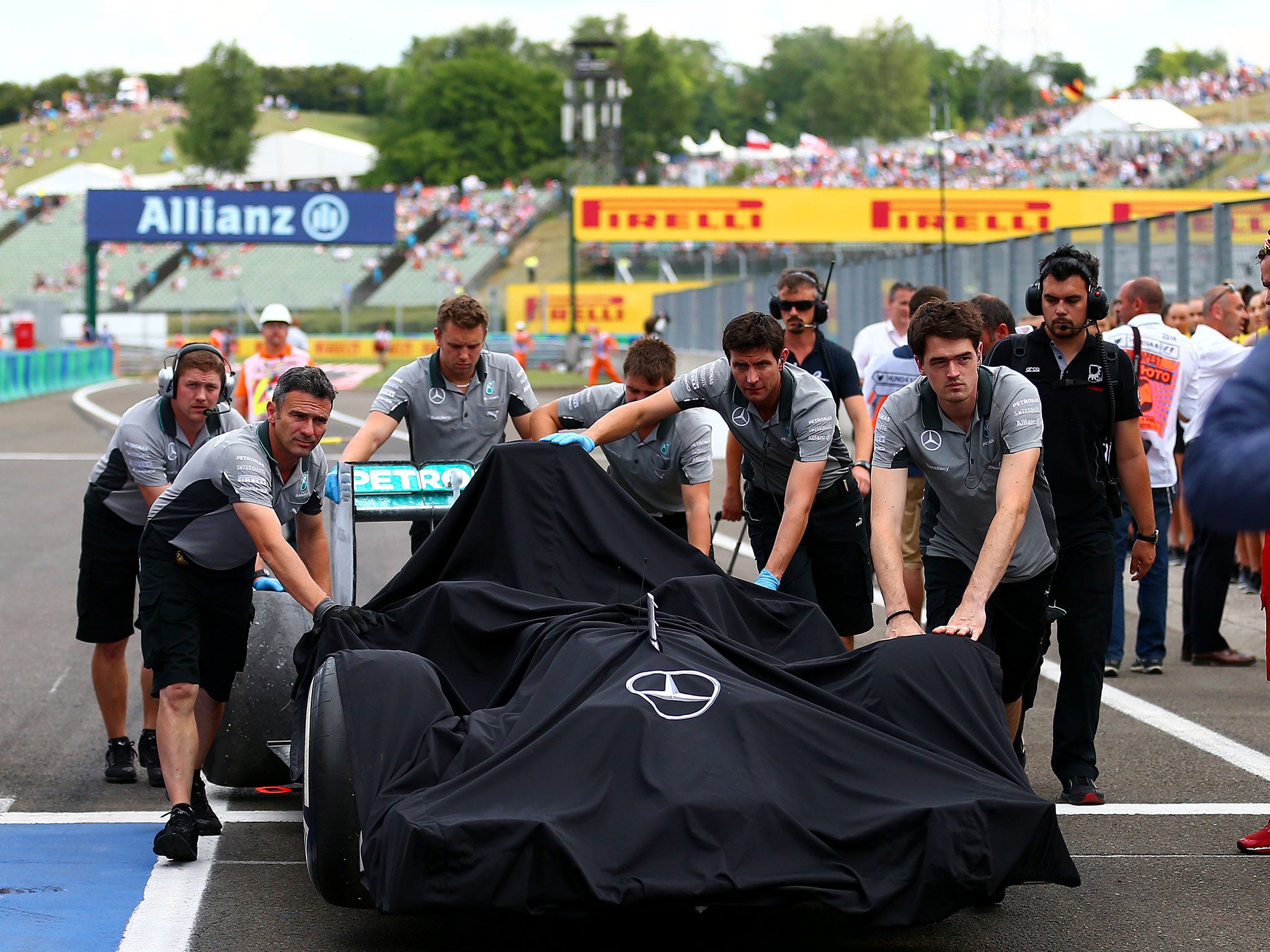 The Mercedes mechanics wheel Lewis Hamilton's burnt out Mercedes back to the pits