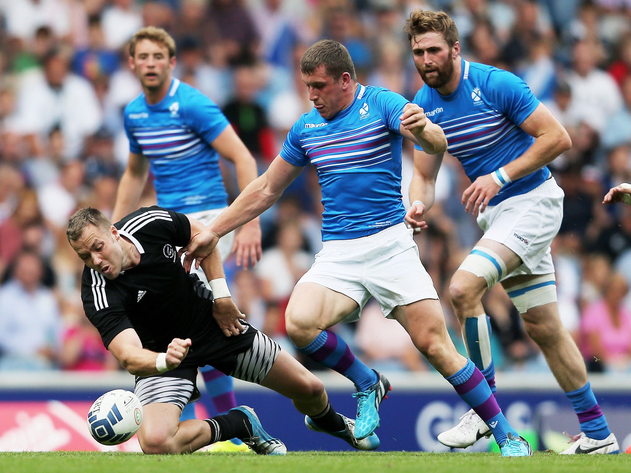 Tim Mikkleson of New Zealand falls on the loose ball in the Rugby Sevens match between New Zealand and Scotland