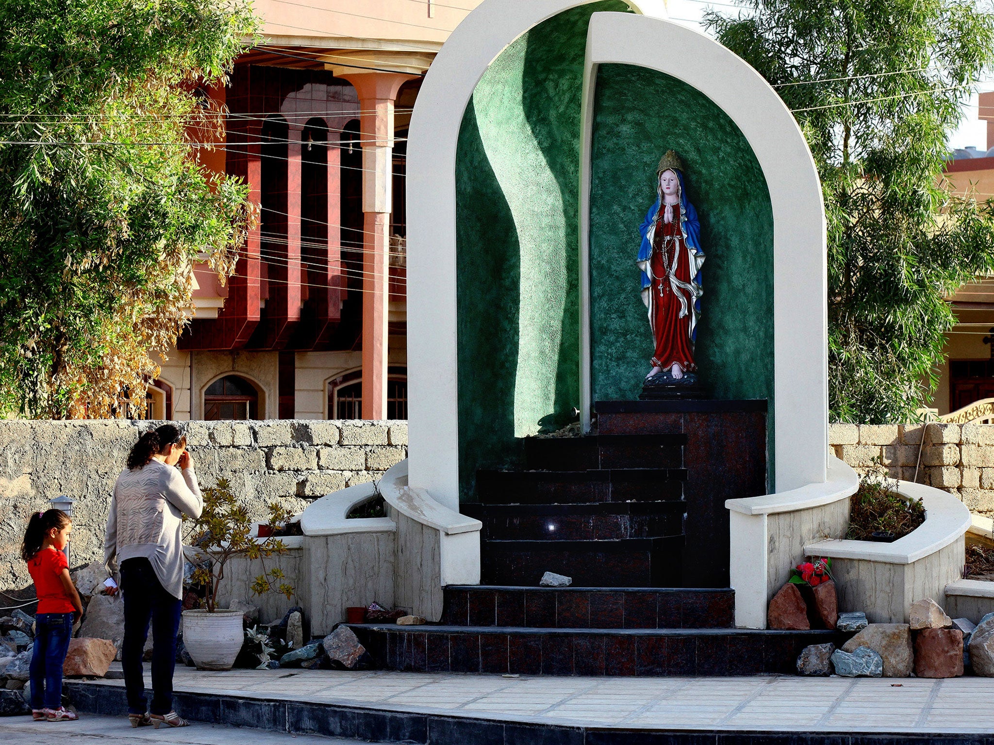 Displaced Christians who fled the violence and threats by Isis in Mosul, northern Iraq, pray at Mar Aframa church in the town of Qaraqoush