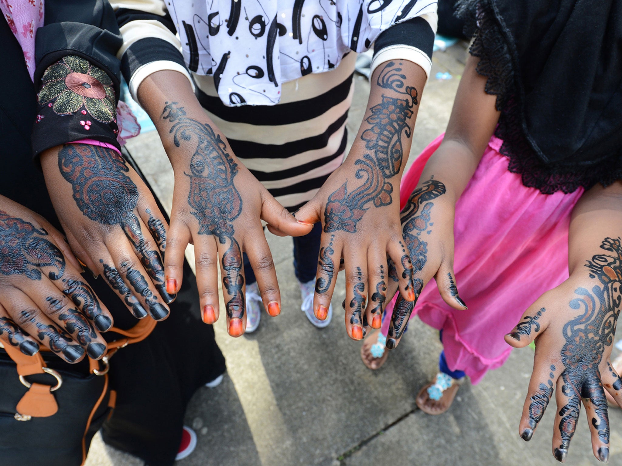 Muslim girls show their hands decorated with henna after attending prayers on Eid Al-Fitr at the Regent's Park Mosque in London in 2012