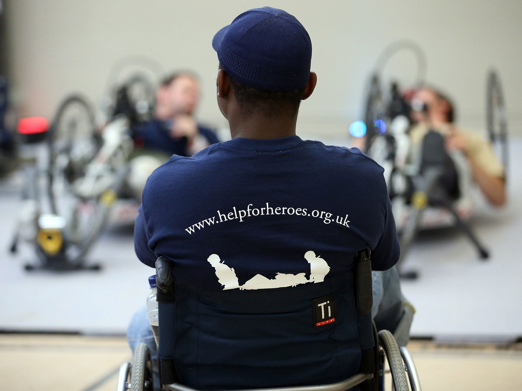 Amputee Corie Mapp watches as other wounded servicemen use some of the exercise machines in the new Help for Heroes' Tedworth House rehabilitation centre for wounded servicemen and women during a press preview day on October 18, 2012 in Tidworth, England.