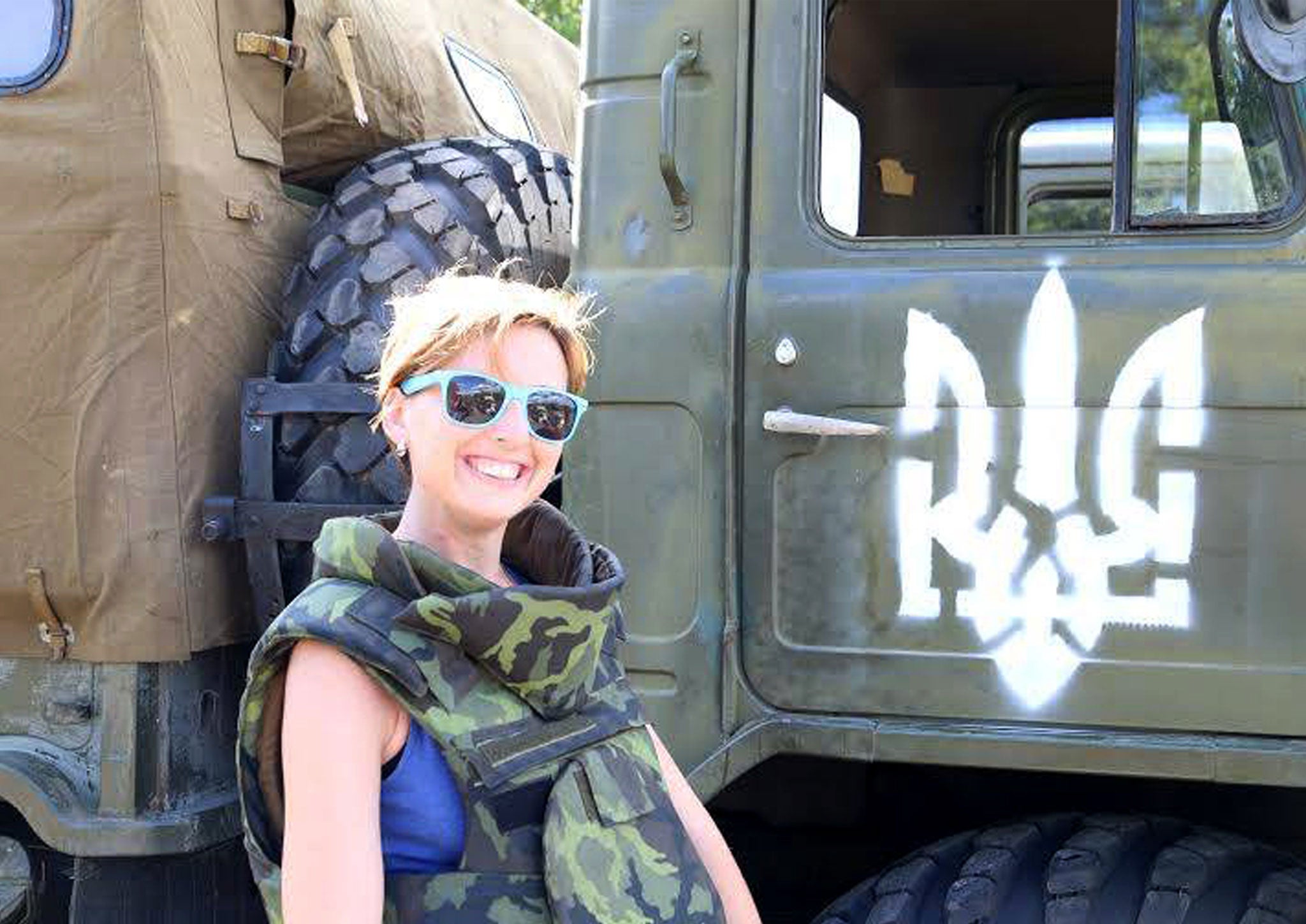 Ilya Bezkorovaynyi poses for the camera in front of a truck in Eastern Ukraine