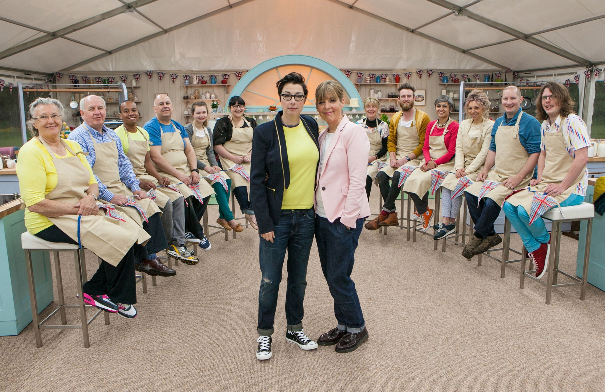 The Great British Bake Off contestants line-up behind Sue and Mel in the Bake Off tent