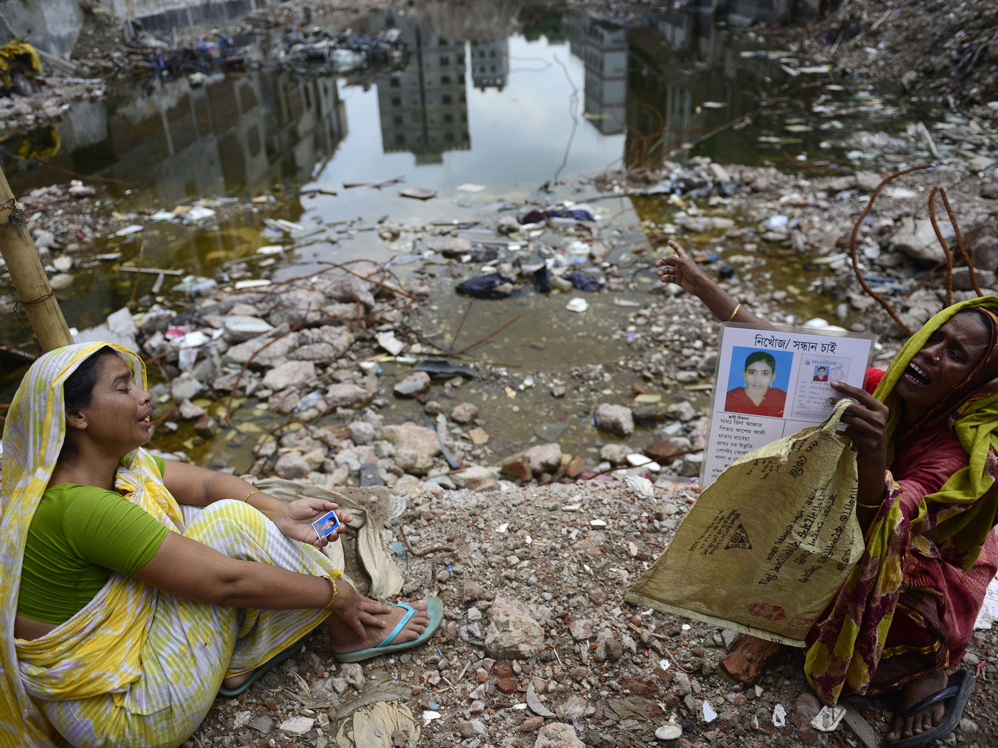 Womem mourn outside the collapsed Rana Plaza garment building