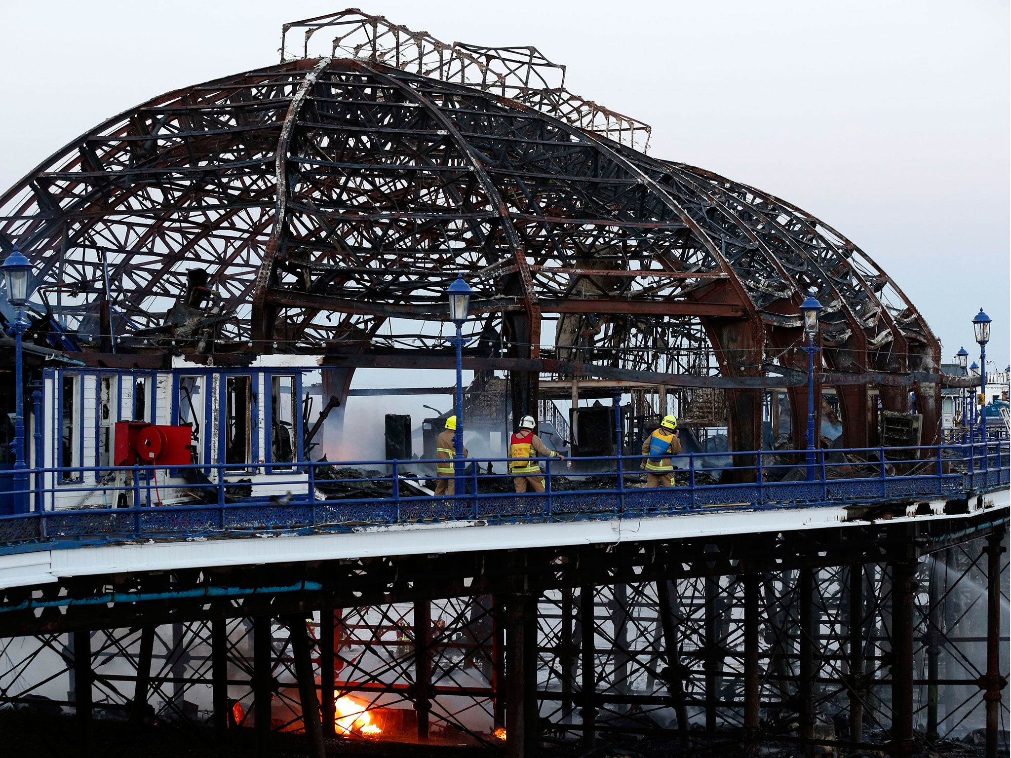 Firemen tackling the final flames of the fire at Eastbourne Pier.