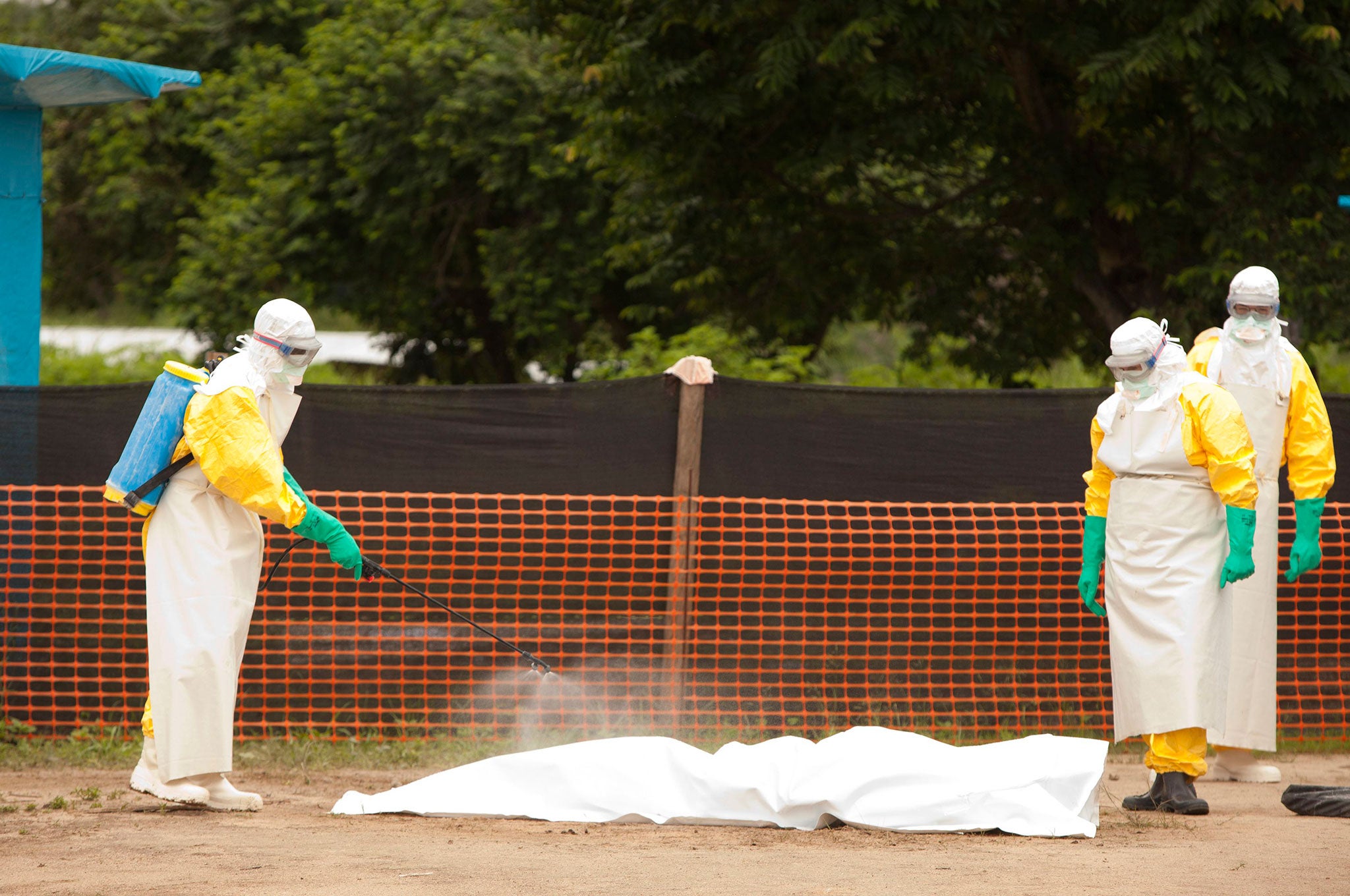 Samaritan's Purse medical personnel spray disinfectant on a person who died from the Ebola virus in the Case Management Center in Foya, Liberia