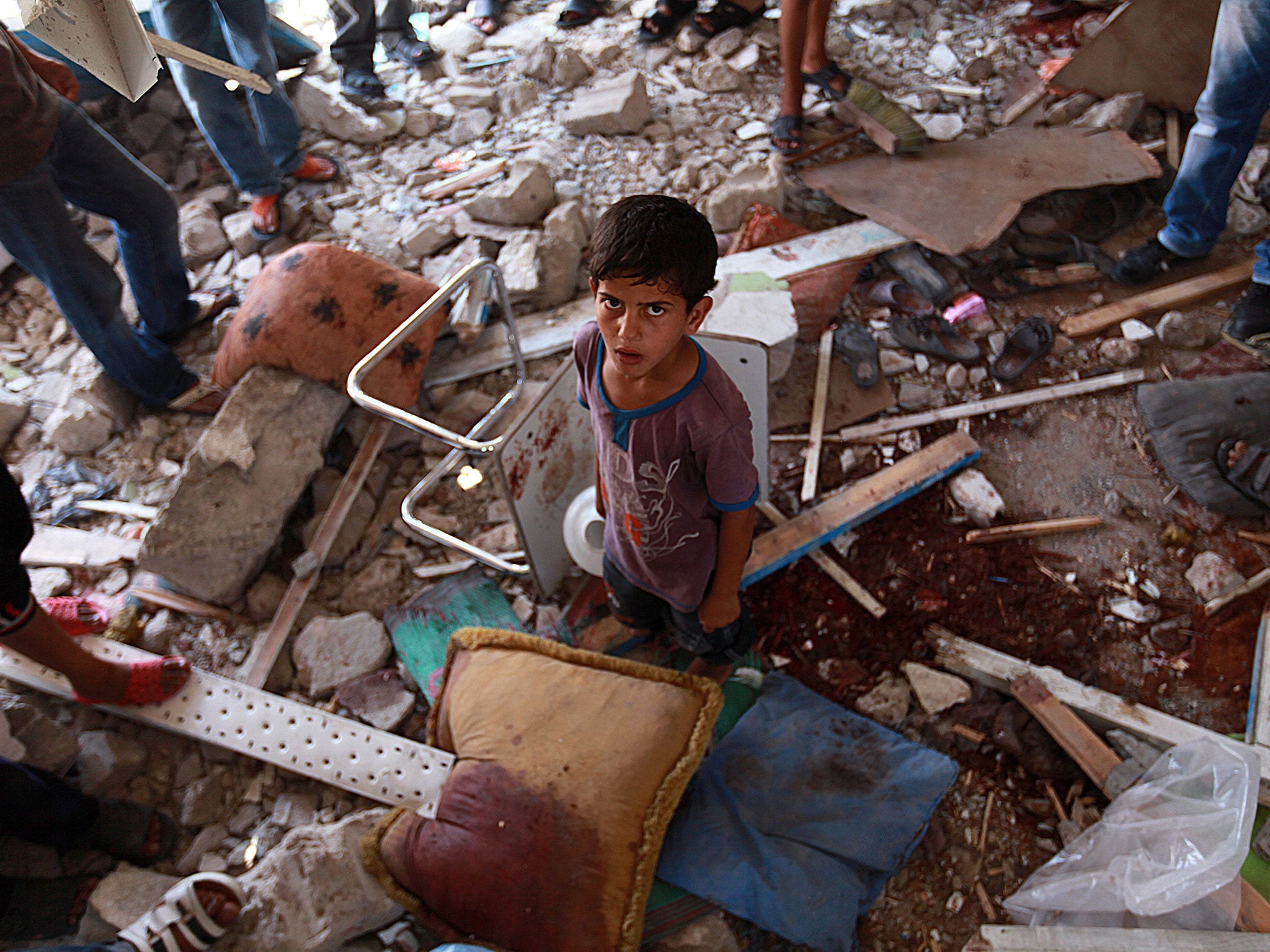 Palestinians inspect a damaged classroom of the UN school in the northern Gaza Strip