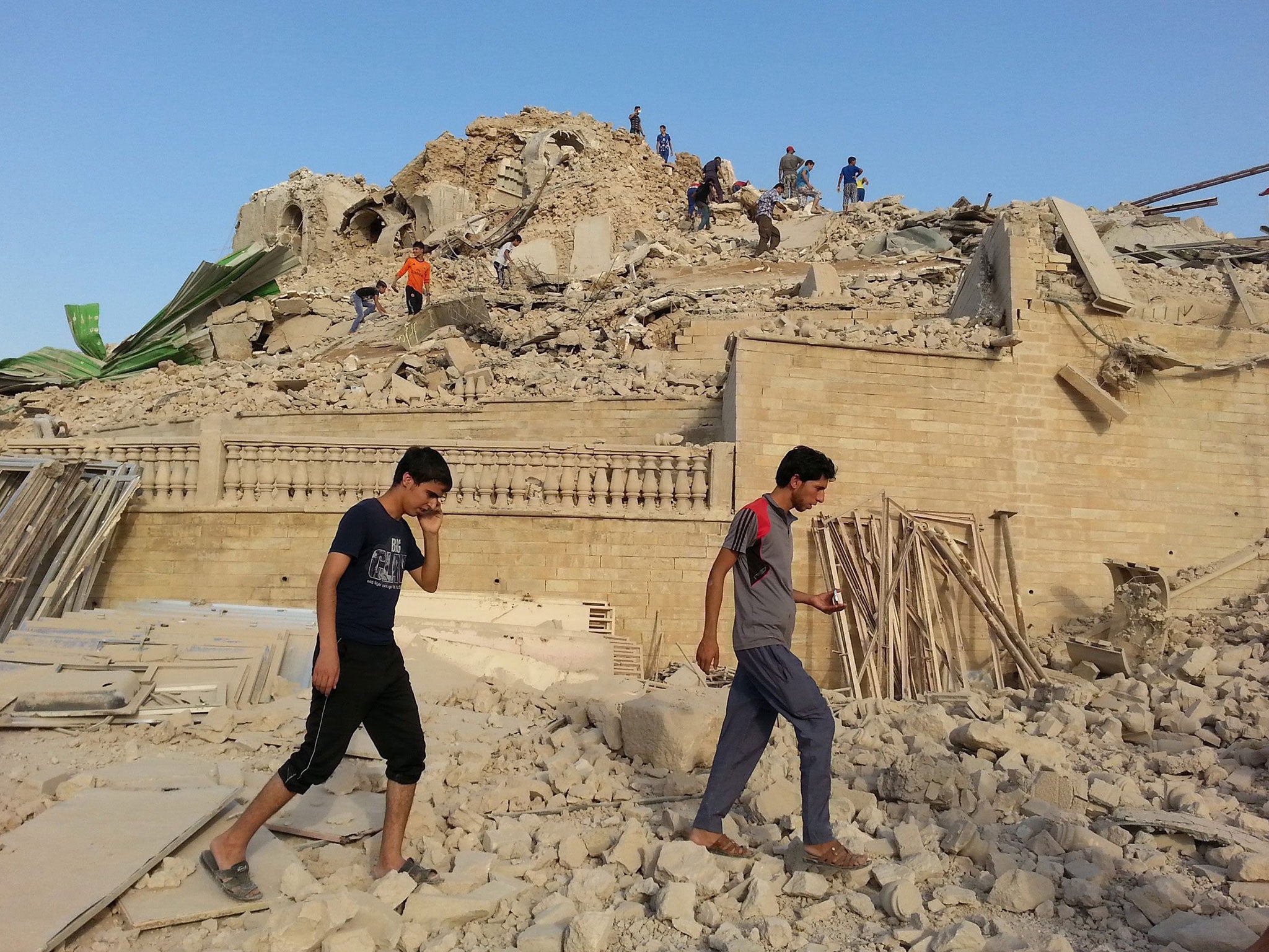 Iraqis inspect the wreckage of the grave of the Nebi Yunus, or prophet Jonah, in Mosul, allegedly demolished by Isis