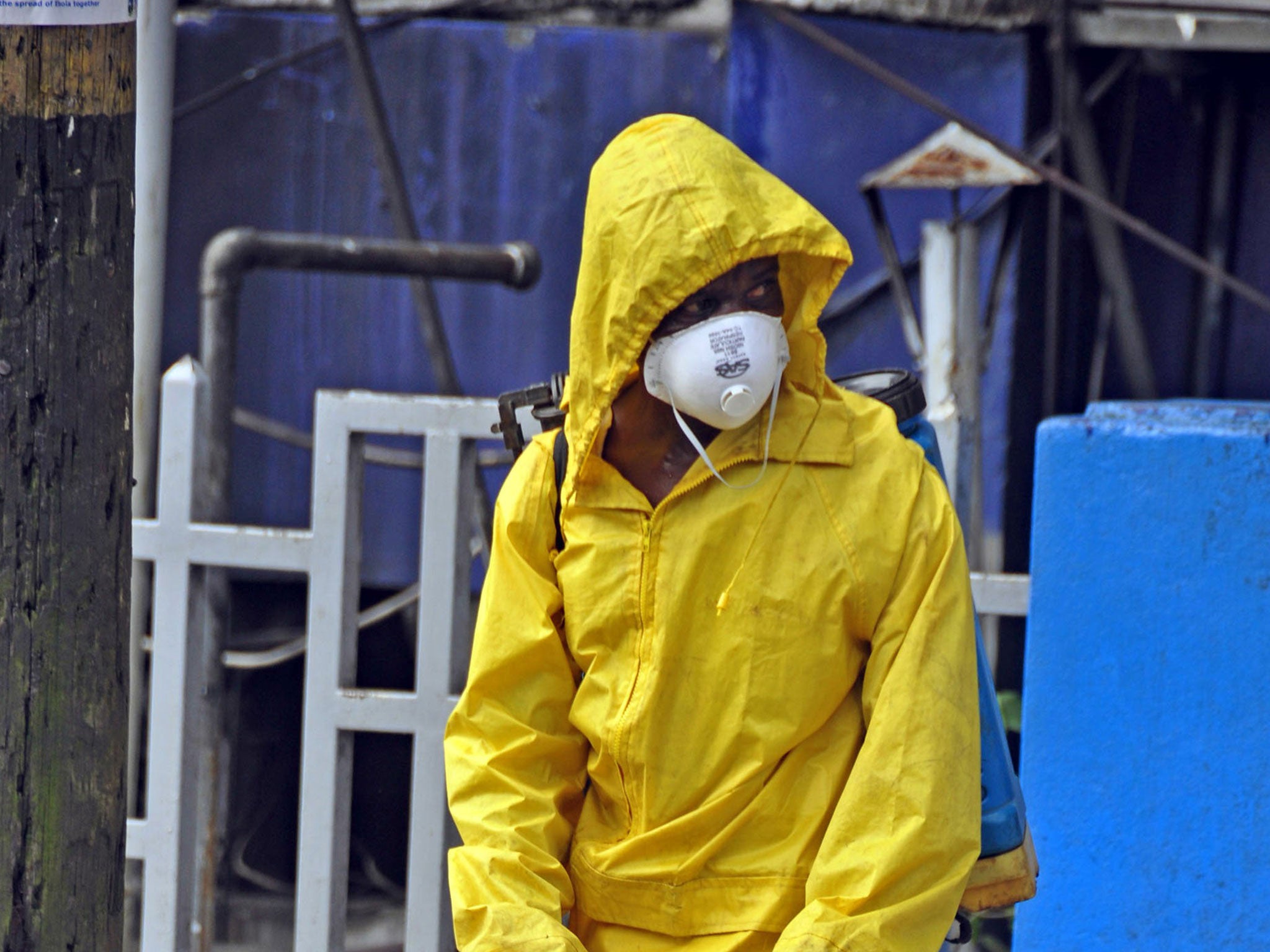 Disinfectant is sprayed on a street in front of a building in a bid to prevent the spread of Ebola