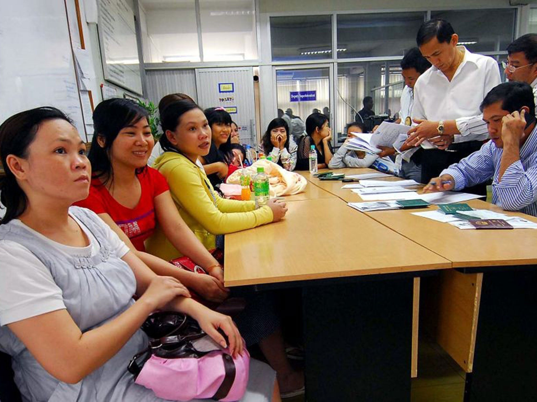 Thai immigration policemen investigate Vietnamese women who were allegedly lured into becoming surrogate mothers