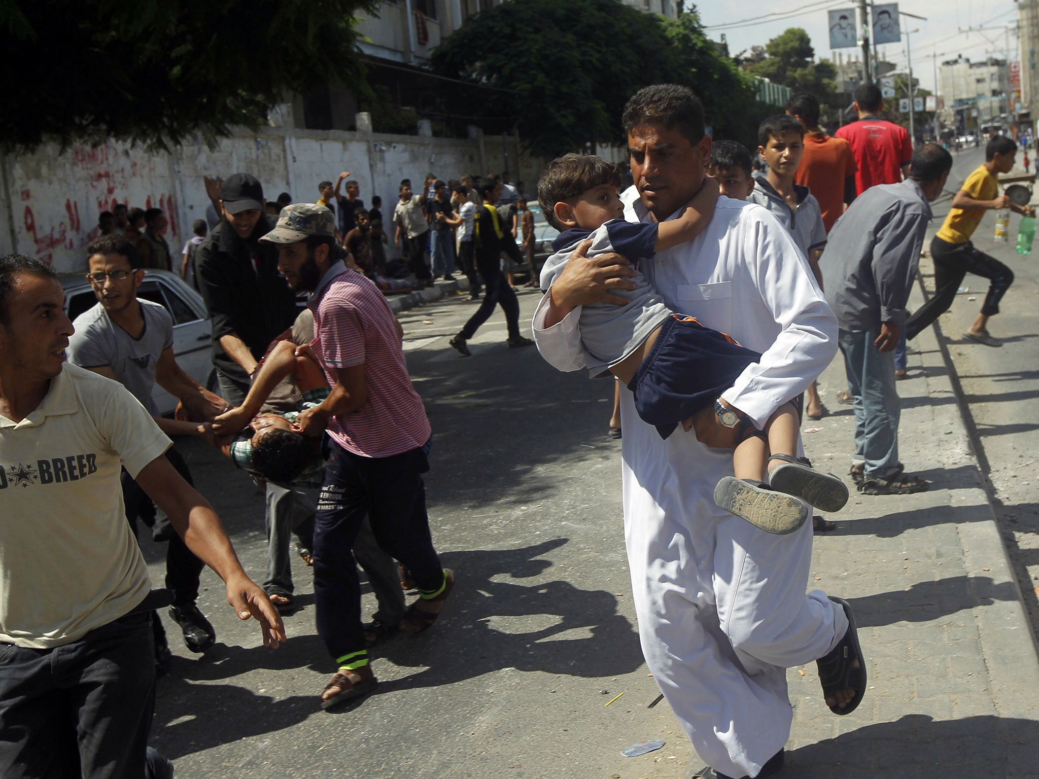 Palestinians carry injured people, including children, following a reported Israeli military strike on a UN school in Rafah