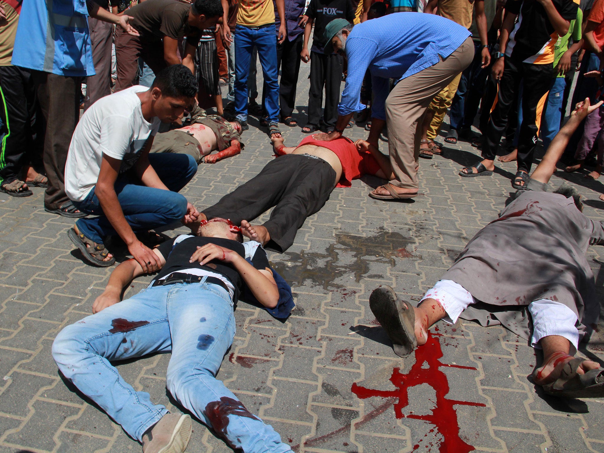 Palestinians aid injured people on the ground following an Israeli military strike on a UN school in Rafah, in the southern Gaza Strip (AFP)