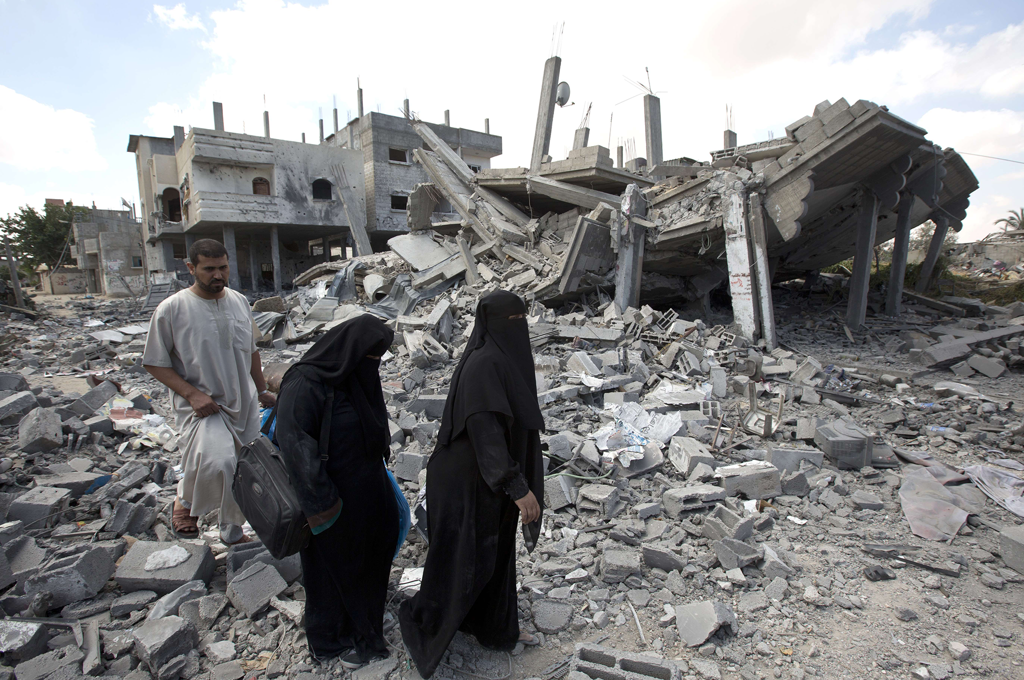 Palestinians return to what is left of their homes and businesses following the Israeli military offensive in Rafah on 1-4 August 2014