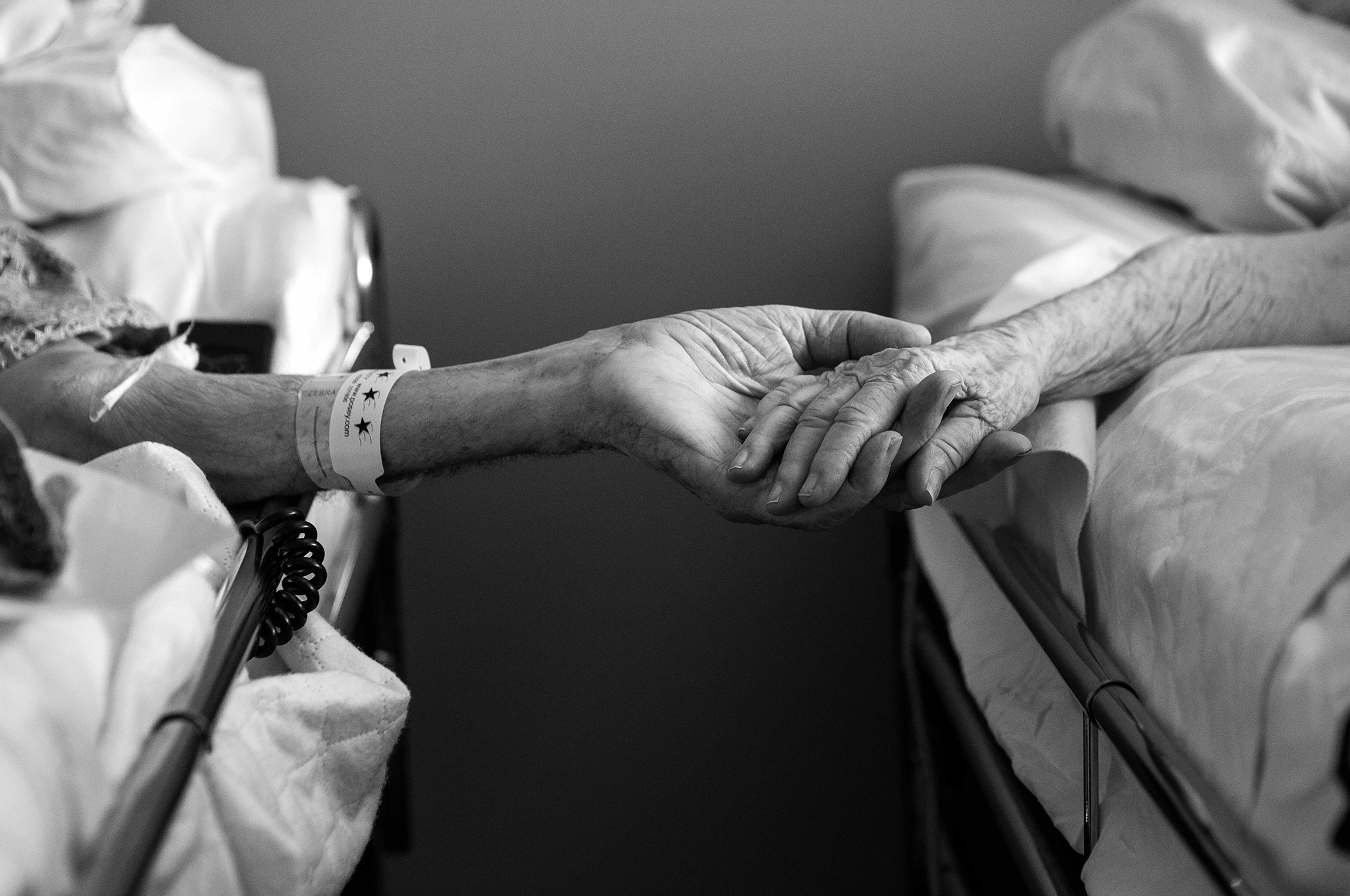 In this photo provided by their granddaughter, Melissa Sloan, Don Simpson, 90, and his wife Maxine, 87, hold hands from adjoining hospice beds in Sloan's home in Bakersfield, Calif.