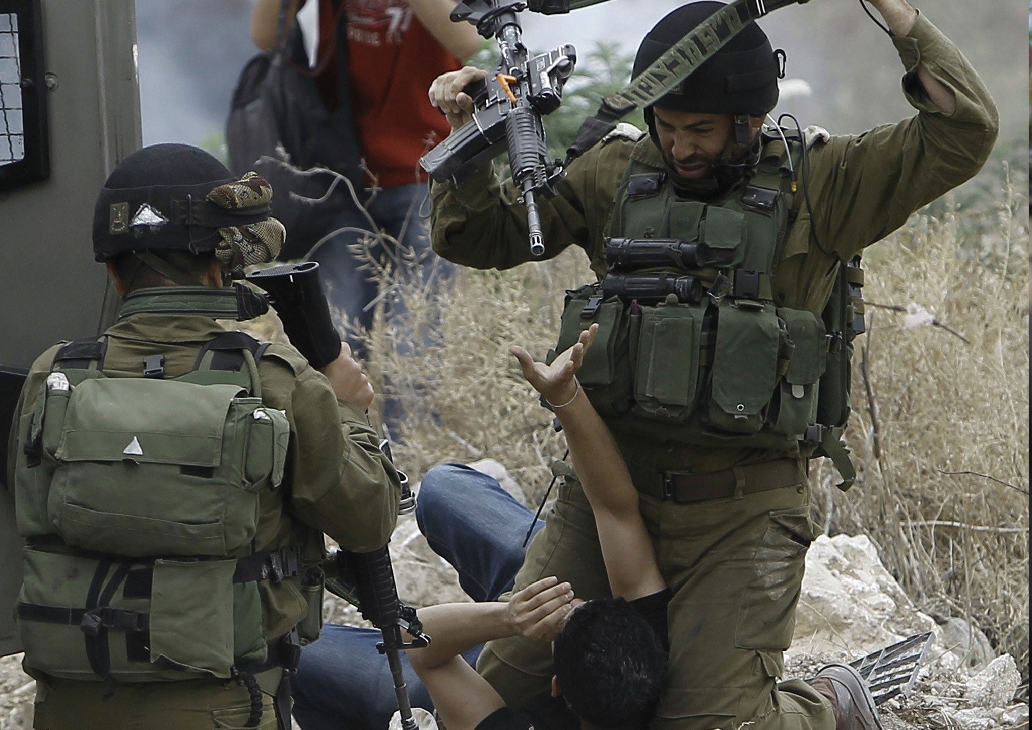 Israeli soldiers detain a Palestinian protester following a demonstration