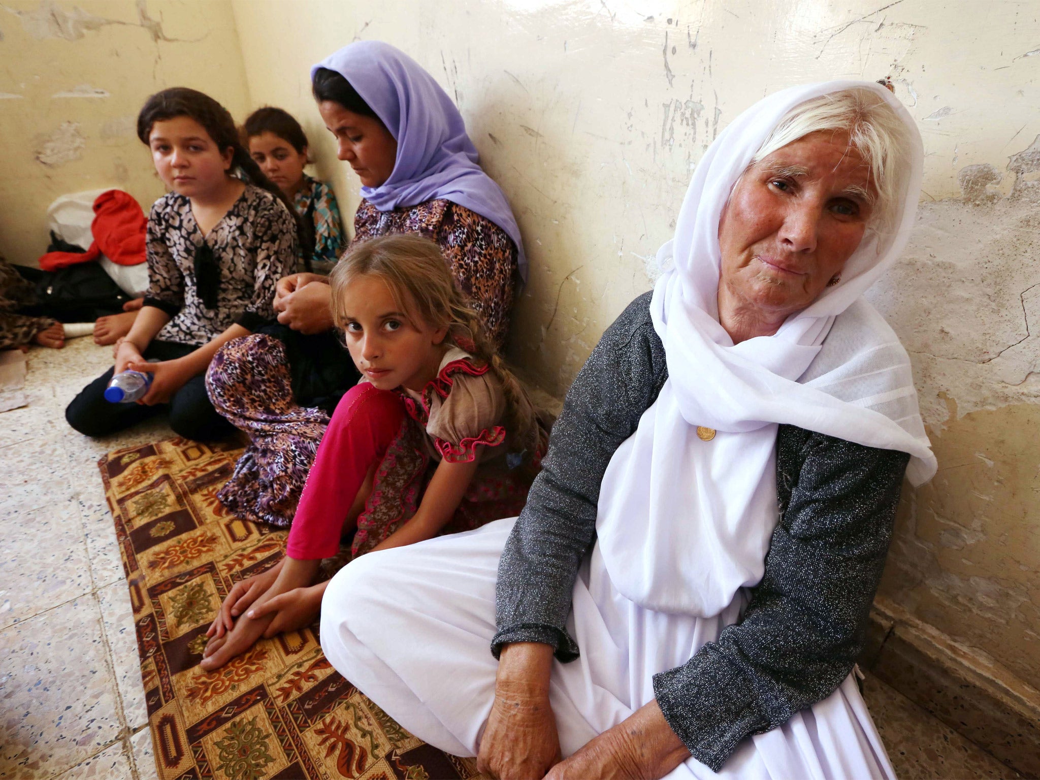 An Iraqi Yazidi family that fled the violence in the northern Iraqi town of Sinjar, sit at at a school where they are taking shelter in the Kurdish city of Dohuk in Iraq’s autonomous Kurdistan region