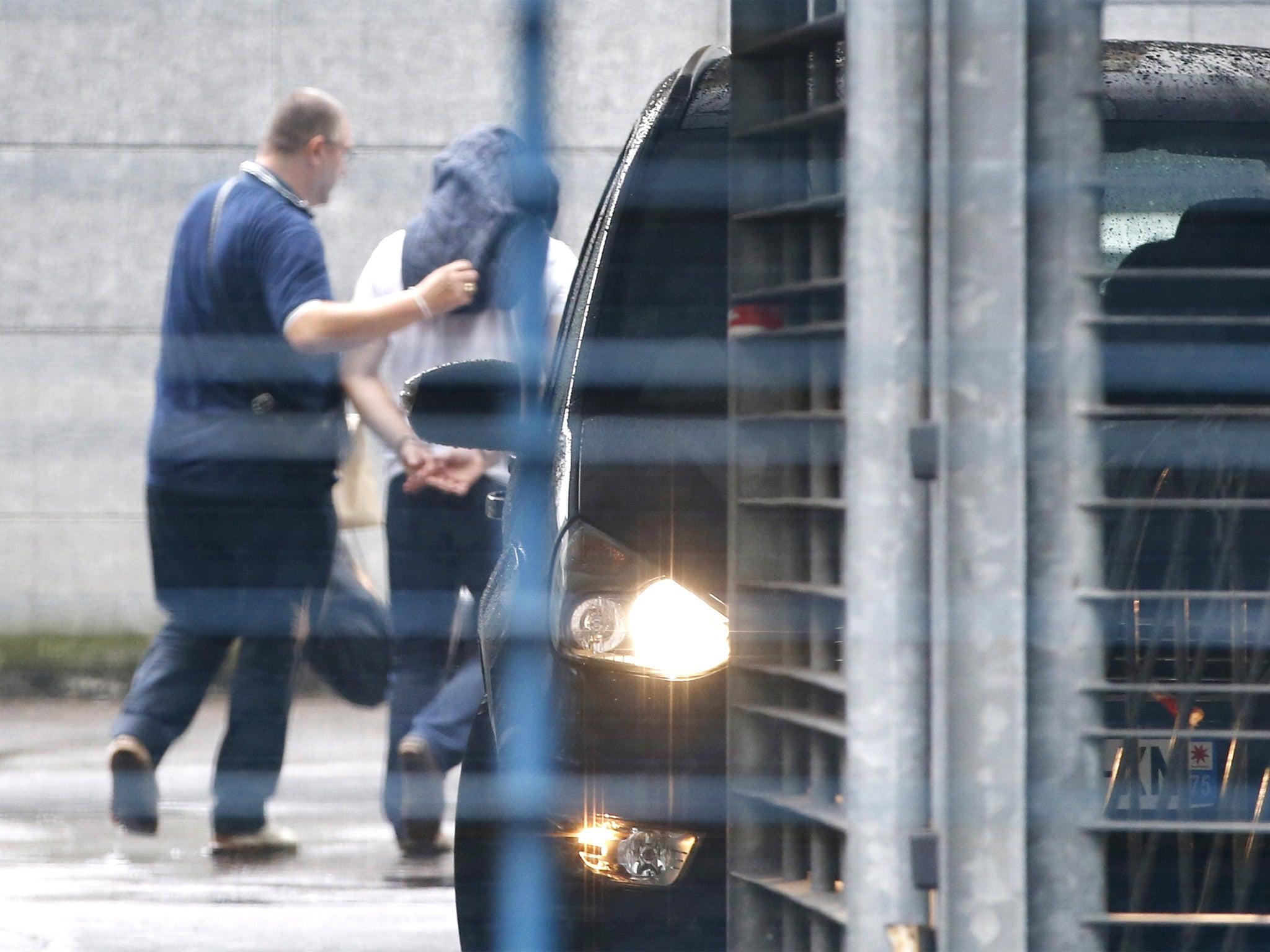 One of the two narcotics officers suspected of taking part in the stealing of over 50 kilos of seized cocaine is escorted by French police