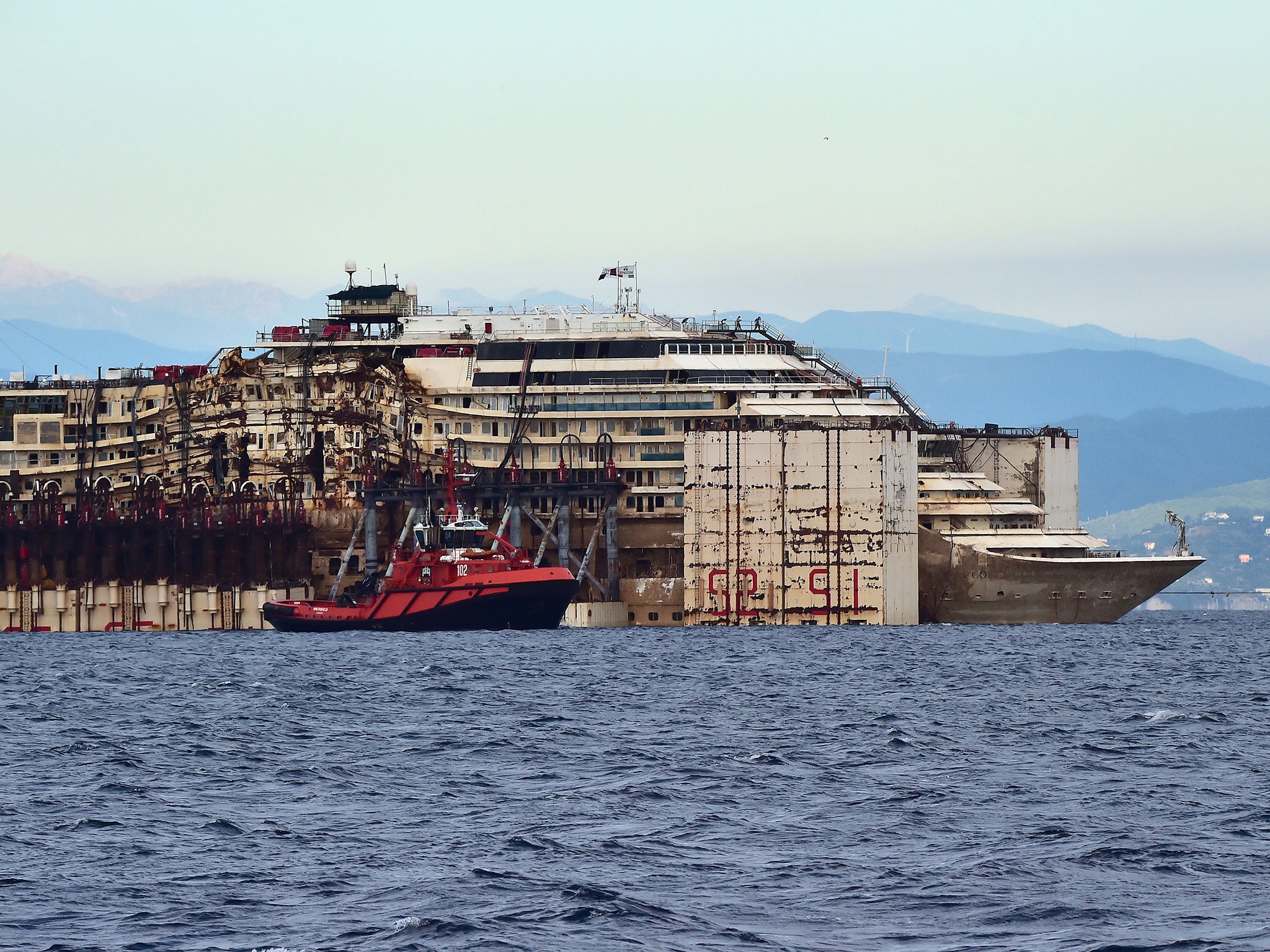 The refloated wreck of the Costa Concordia cruise ship as it was dragged to the harbor of Pra di Voltri near Genoa