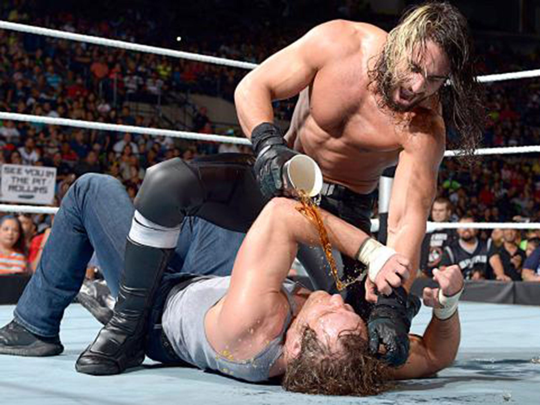 Seth Rollins pours a drink over Dean Ambrose