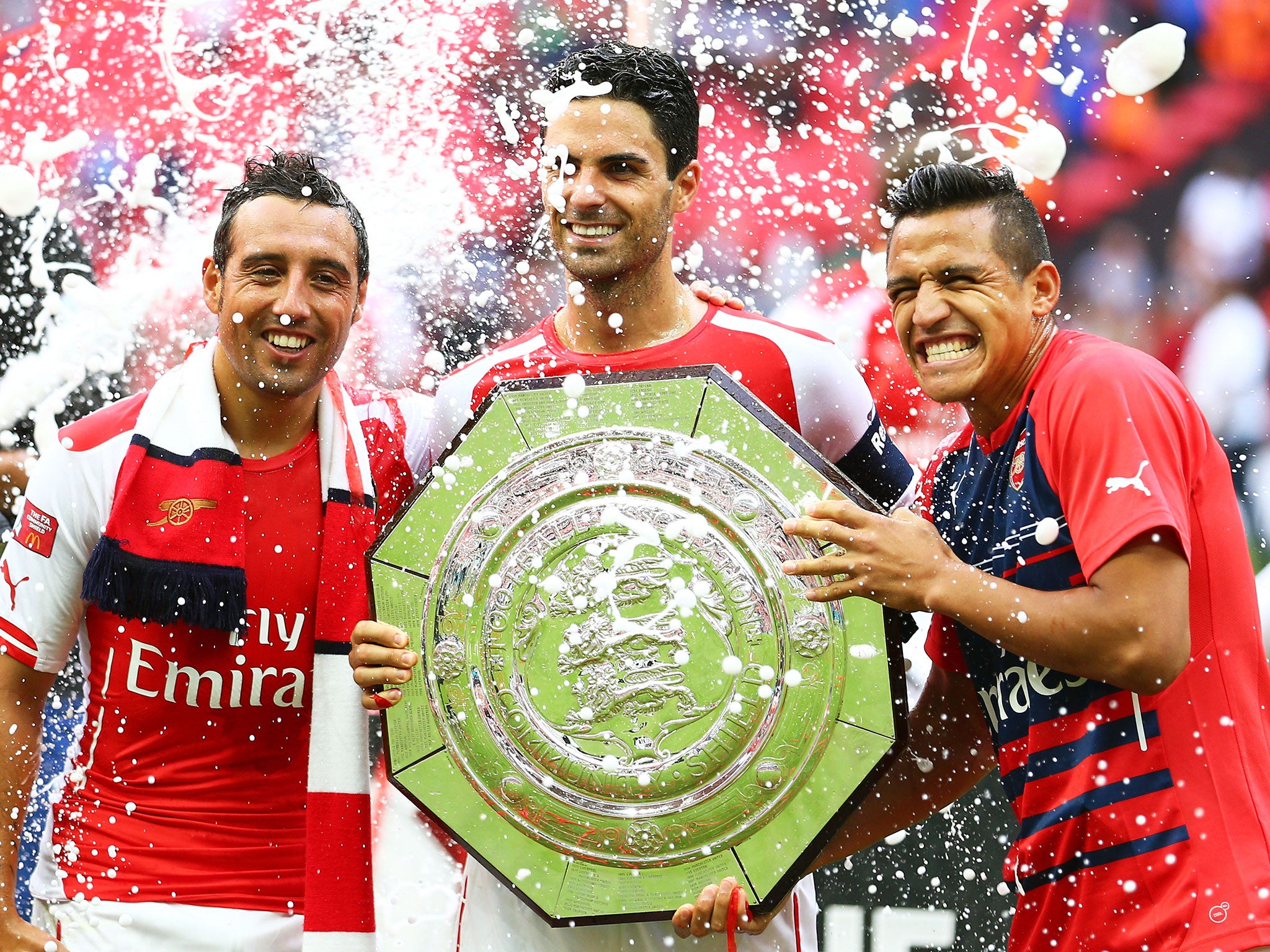 Mikel Arteta poses with the Community Shield alongside Santi Cazorla (left) and Alexis Sanchez (right)