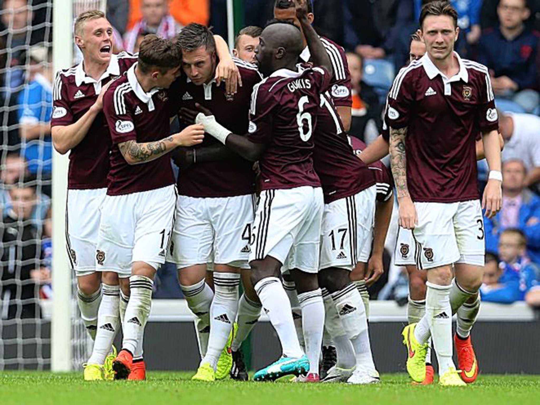 Team-mates congratulate Hearts’ Danny Wilson after he scored the opening goal at Ibrox