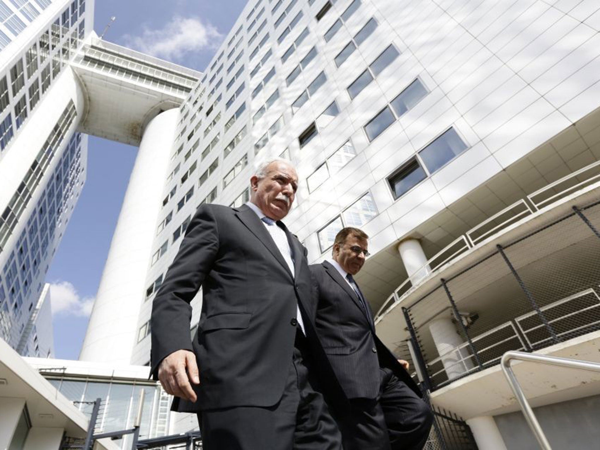 Palestinian Foreign Minister Riad al-Malki, left, leaves the International Criminal Court in The Hague, on August 5, 2014